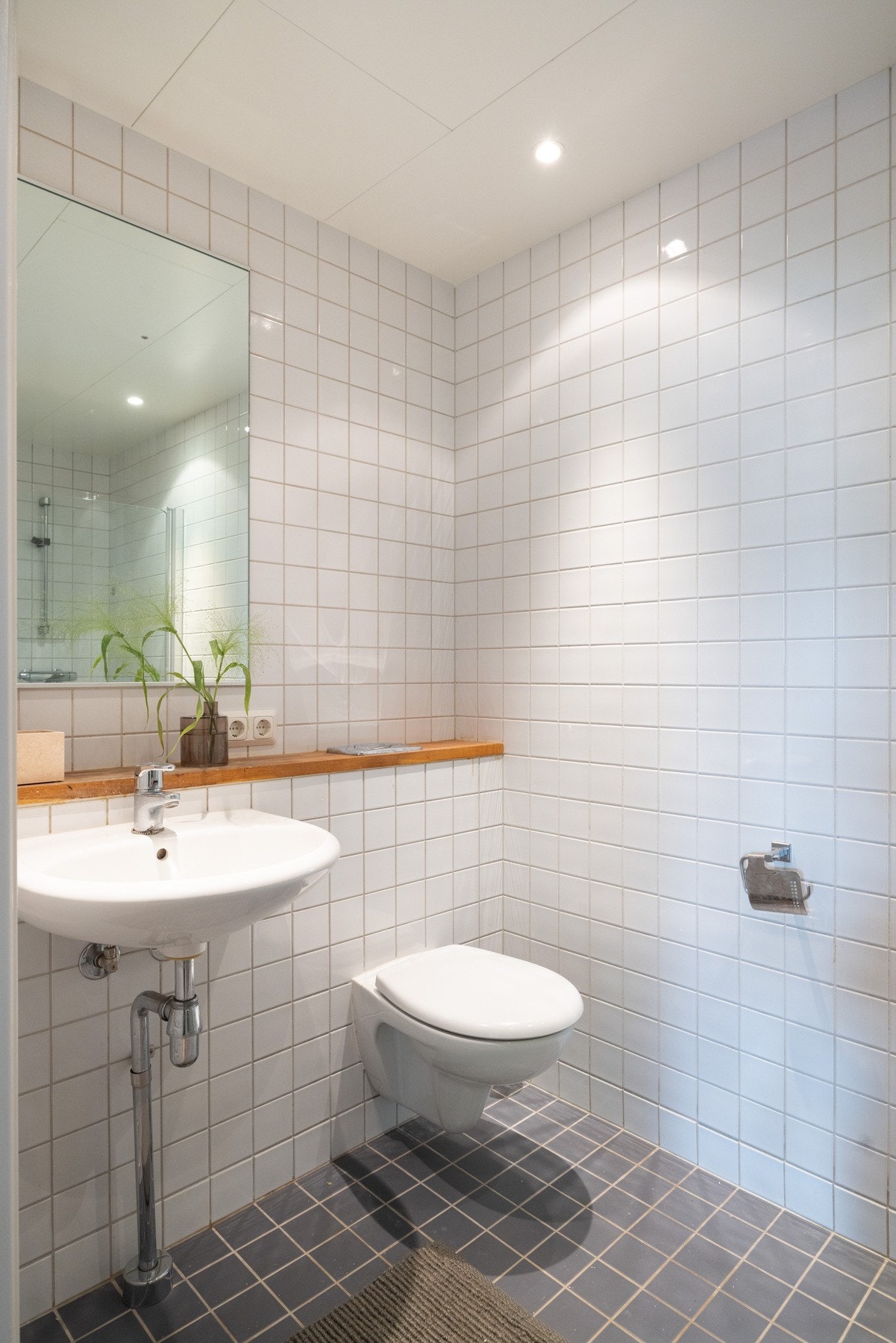 Badet er innredet med dusjhjørne, servant og vegghengt toalett. Galleribilde