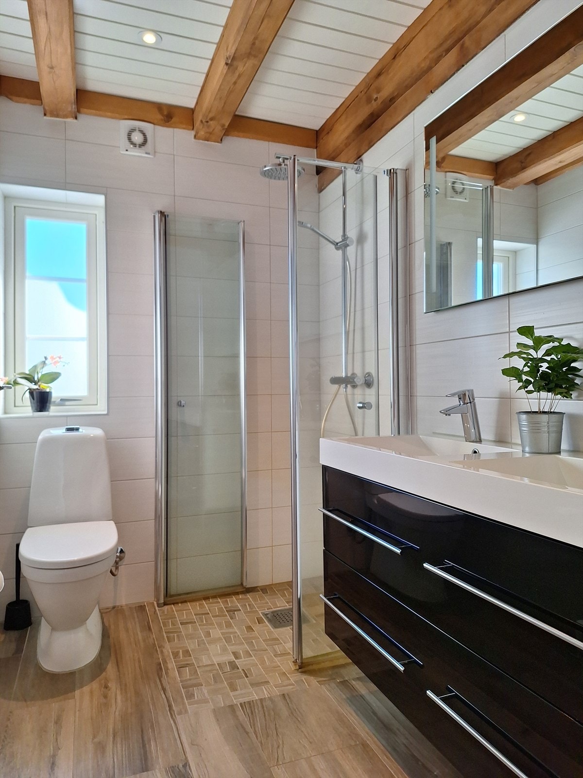 Bad nr. 3 ligger i tilknytning det 2. soverommet i 1. etasje. Badet er innredet med gulvstående toalett, vegghengt servantinnredning med dobbel servant og dusjhjørne med glassdører og vegghengt dusjarmatur. Galleribilde