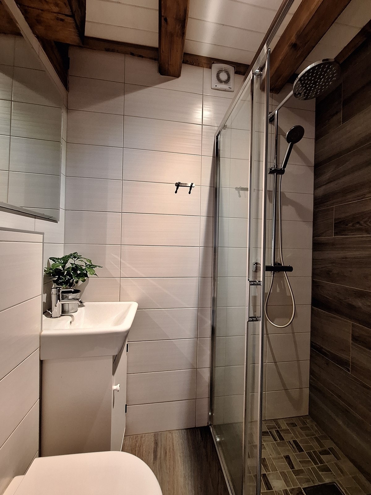 Bad nr.2 ligger i tilknytning det ene soverommet i 1. etasje. Badet er innredet med vegghengt toalett, vegghengt servantinnredning og dusj med glassdører og vegghengt dusjarmatur. Galleribilde