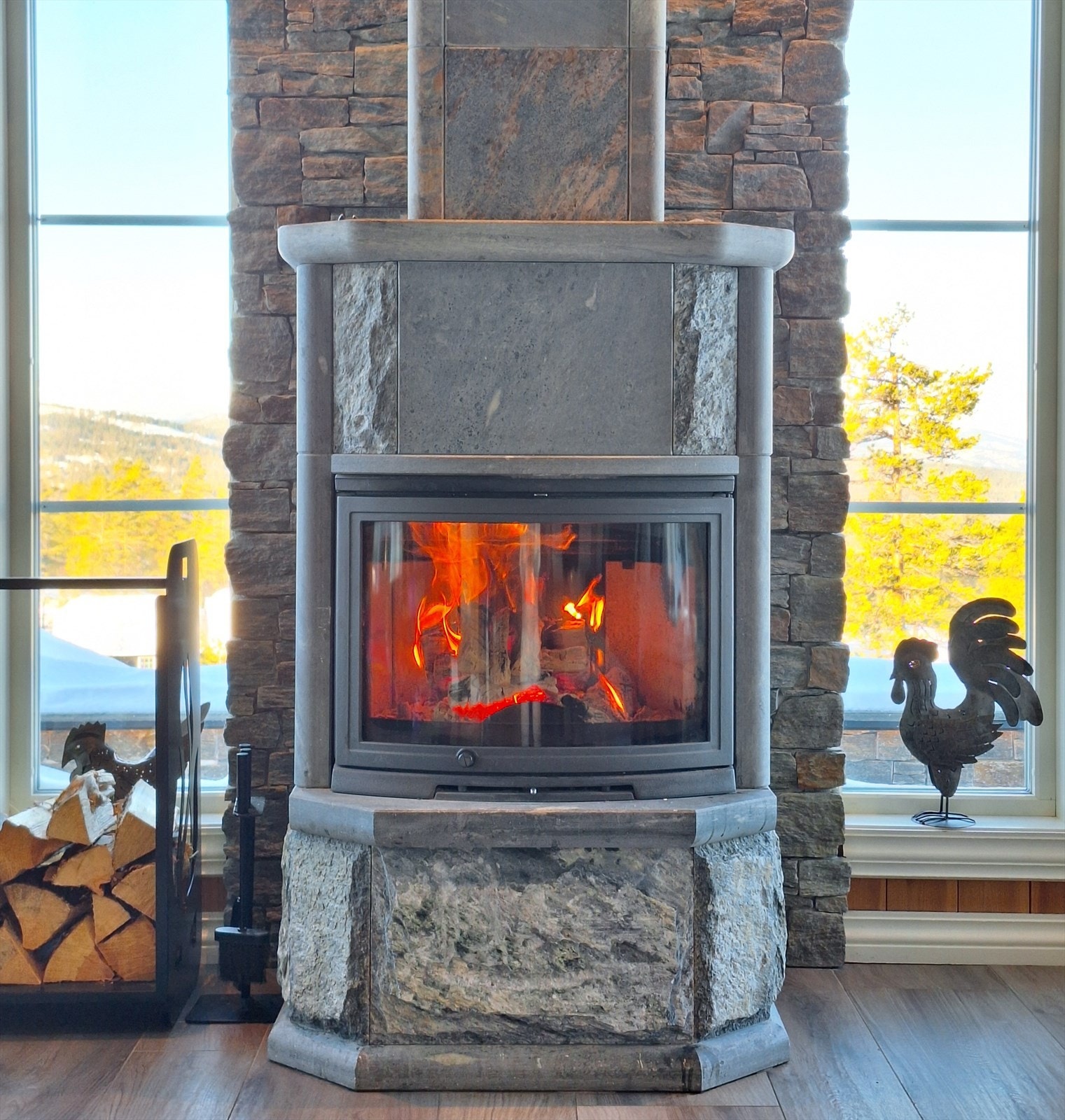 Deilig peisovn i stue med elementpipe forblendet av steinpaneler. Det er også montert luft-til-luft varmepumpe i stue. Galleribilde