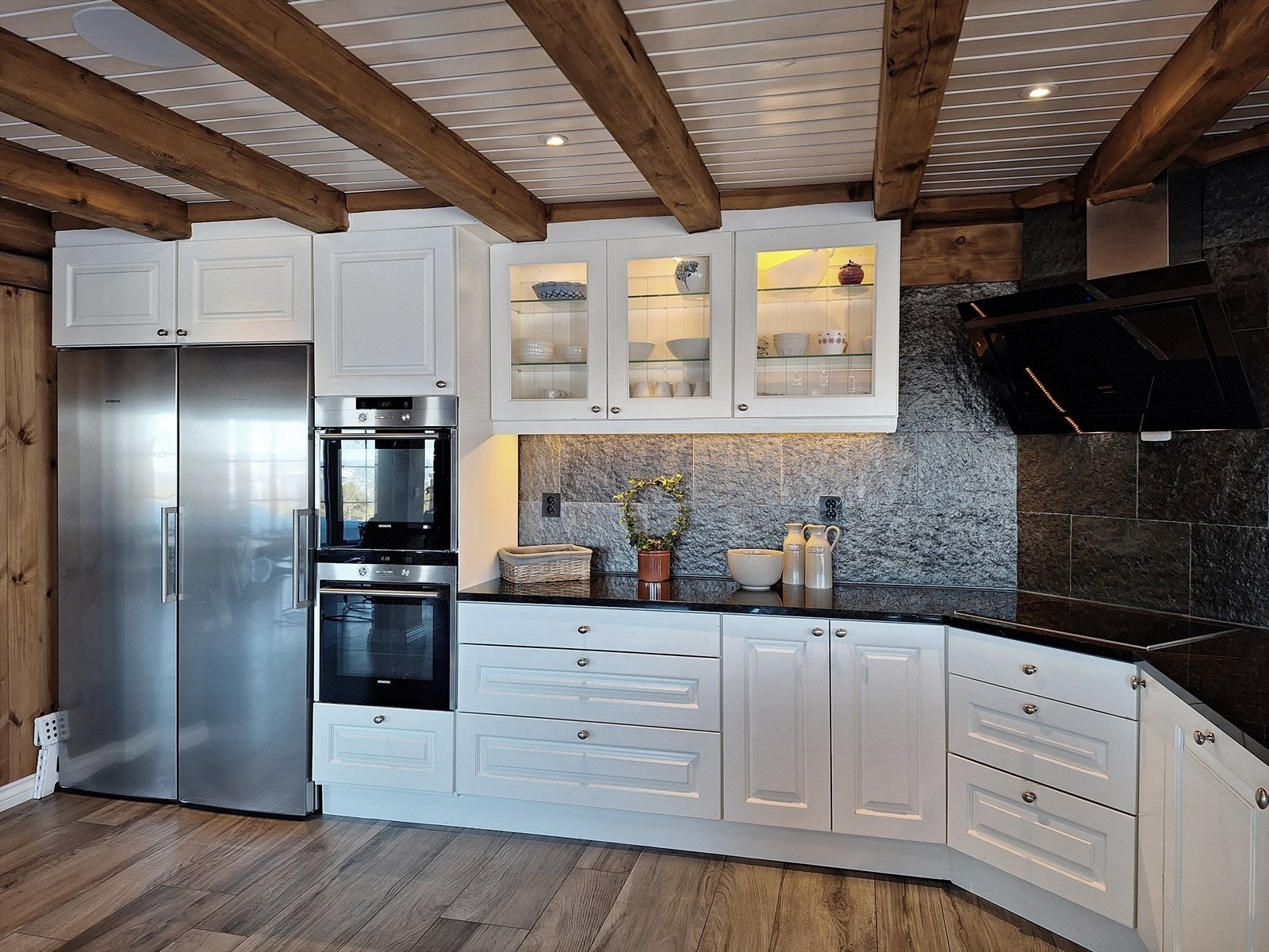 Kjøkkenet er rikelig utstyrt med integrerte hvitevarer, herunder 2 stekeovner, 2 oppvaskmaskiner, induksjon platetopp og vinskap. I tillegg er det en egen nisje med plass til dobbelt kjøle-/fryseskap. Galleribilde