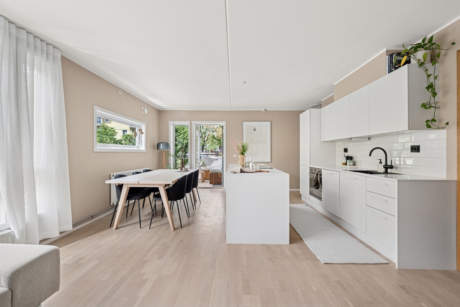 Kjøkkenet og stuen er i en åpen løsning med god avstand mellom sonene - noe som gir både romfølelse og praktisk oppdeling. Galleribilde