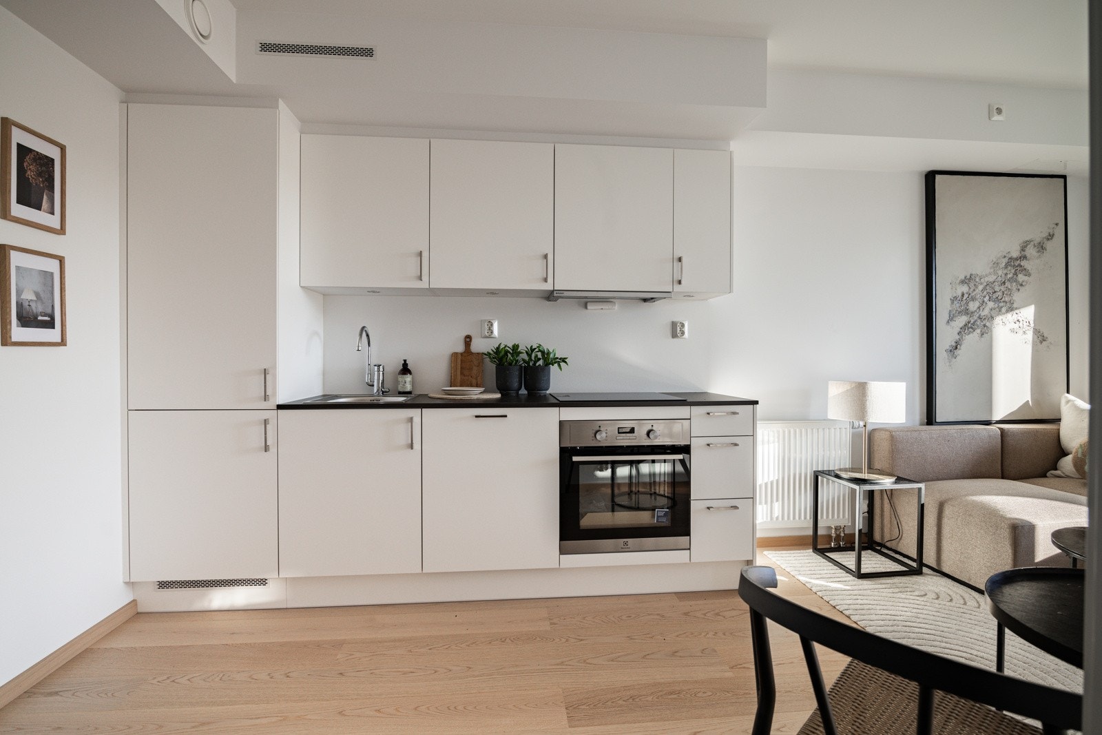 Stilrent kjøkken i åpen løsning mot stuen, med moderne design. Galleribilde