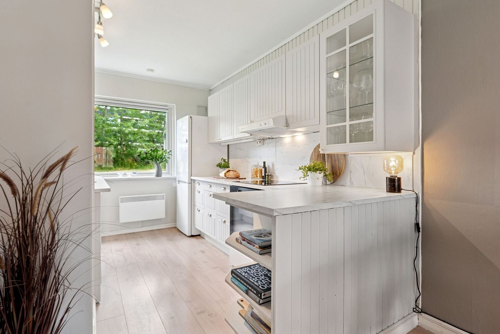 Kjøkkenet har tidløs innredning med god skap- og benkeplass. Innredningen ble oppgradert i 2022 med blant annet ny benkeplate, vask og blandebatteri. Galleribilde