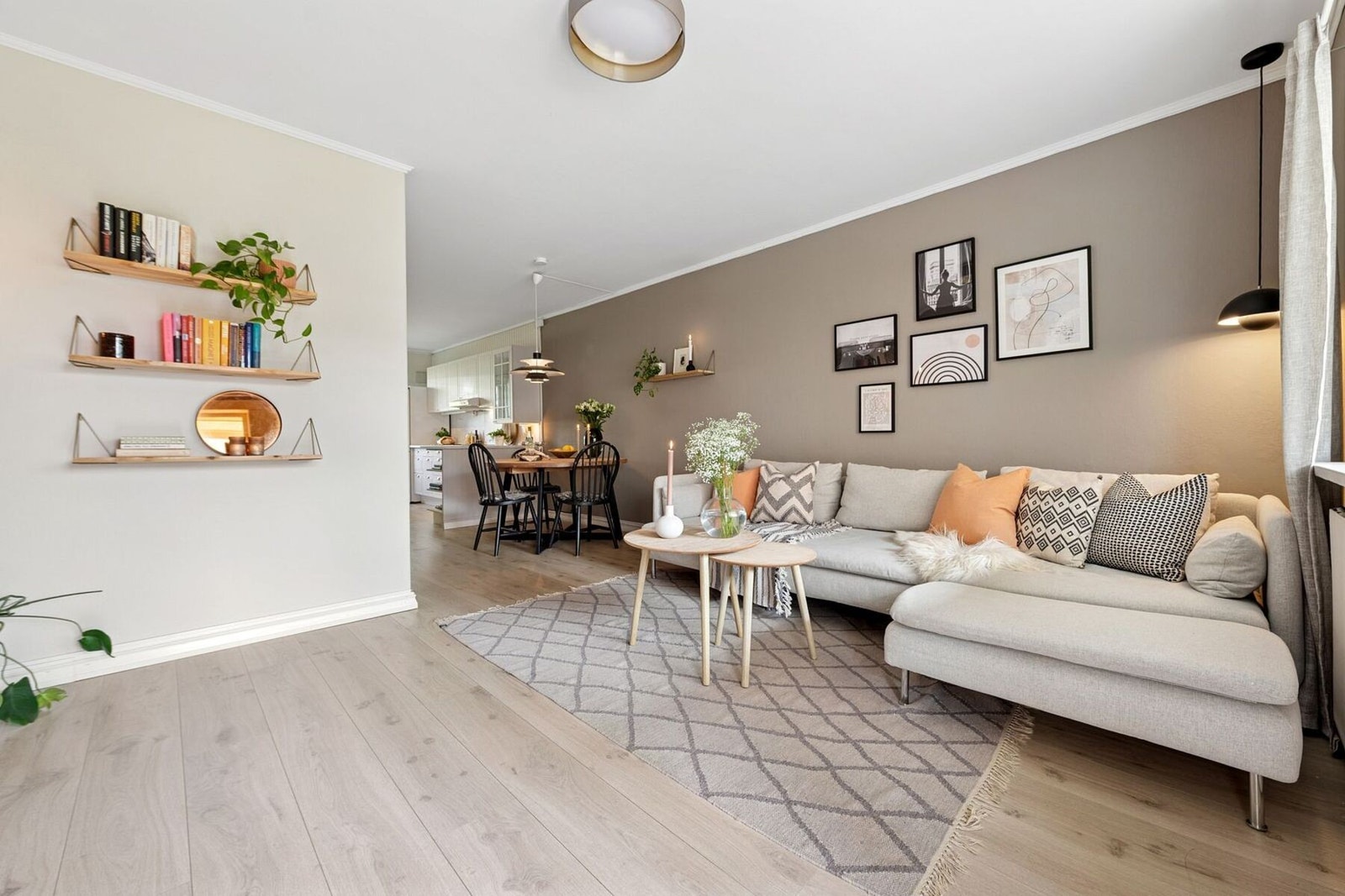 Kjøkkenet ligger i tilknytning til stuen, samtidig i en egen sone av leiligheten - en løsning som gir rom for både sosialt samvær og naturlig flyt i hverdagen Galleribilde