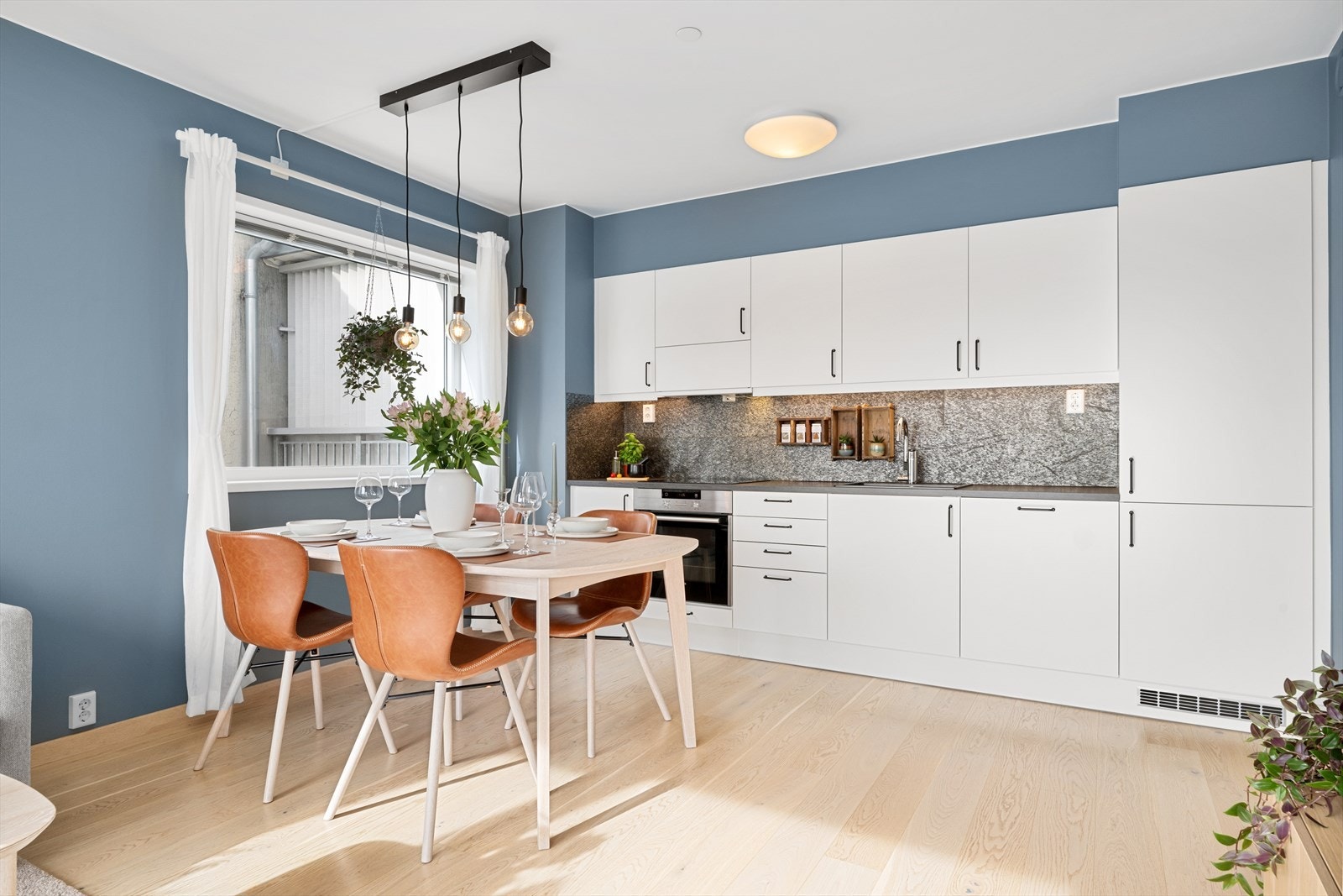 Kjøkkenet er levert av HTH og holder en moderne, tidløs stil med slette, hvite fronter og godt med skap- og benkeplass. Galleribilde