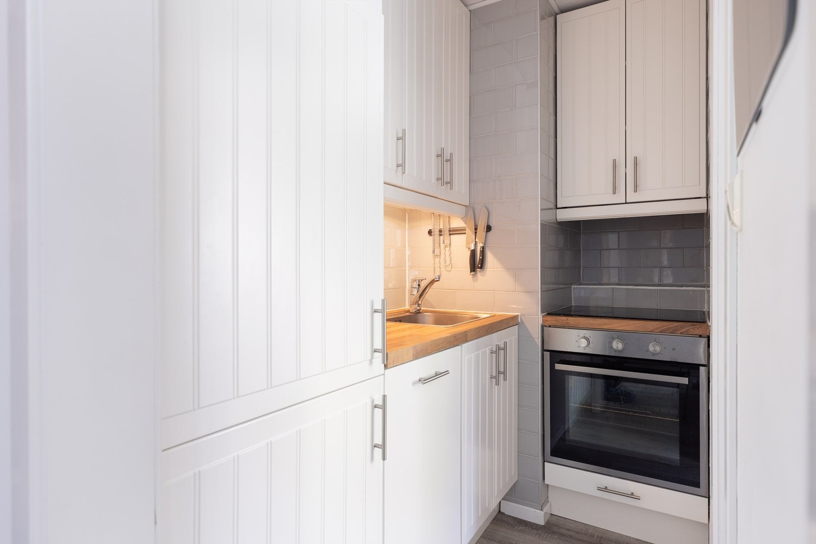 Integrerte hvitevarer med induksjon platetopp, stekeovn, kombiskap (kjøl/frys) og oppvaskmaskin. Galleribilde