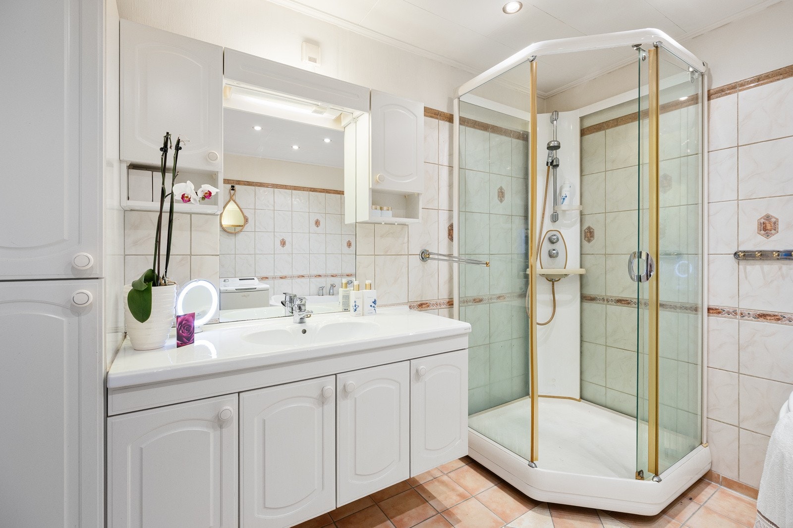 Badet er blant annet utstyrt med toalett, et dusjkabinett og et hjørnebadekar. Galleribilde