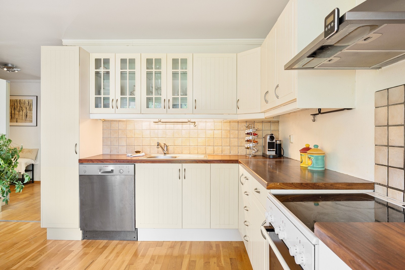 Innredningen fra Ikea har lyse, profilerte fronter, vitrinedører og gyllen laminatbenkeplate. Galleribilde