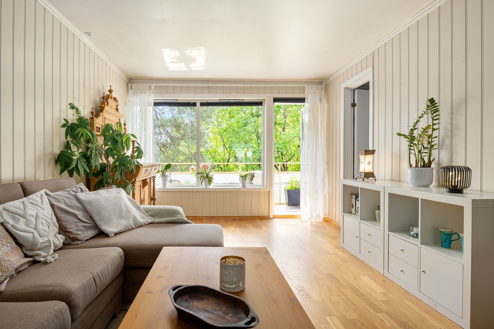 Dagslyset strømmer inn til stuen via store, sydvestvendte vindusflater. Galleribilde