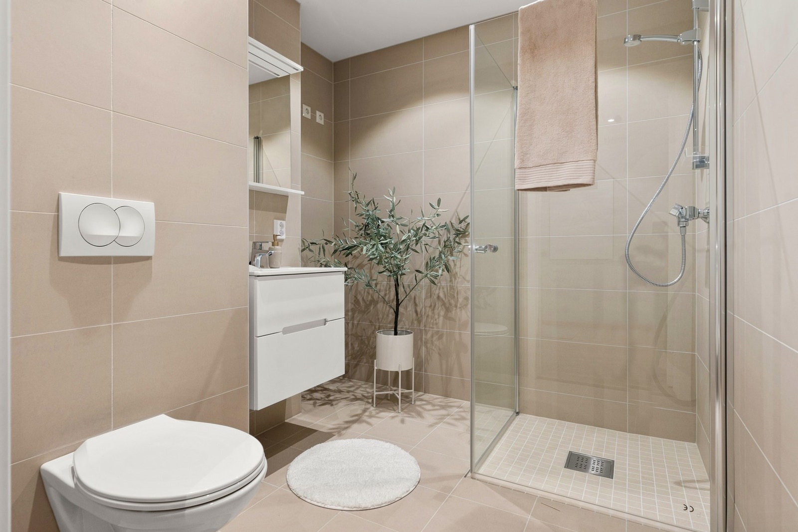 Badet kombinerer vaskeromsløsning og moderne flislagt utførelse for maksimal funksjonalitet. Galleribilde