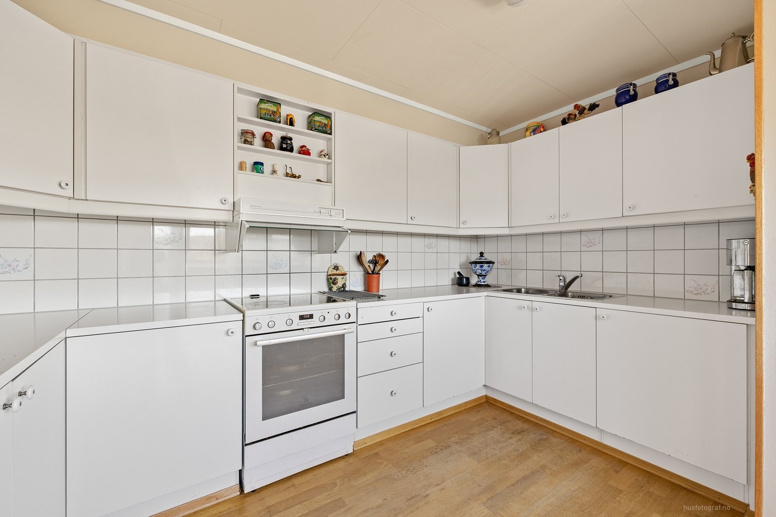 Innredningen har avsatt plass for frittstående komfyr og kjøleskap. Over komfyren er det installert ventilator med avtrekk ut. Galleribilde