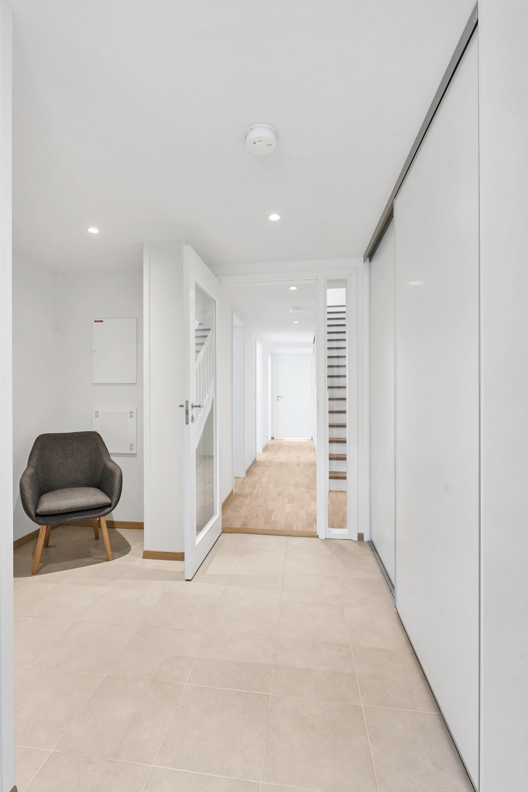 Flislagt entré med skyverdørsgarderobe for oppbevaring av yttertøy. Galleribilde