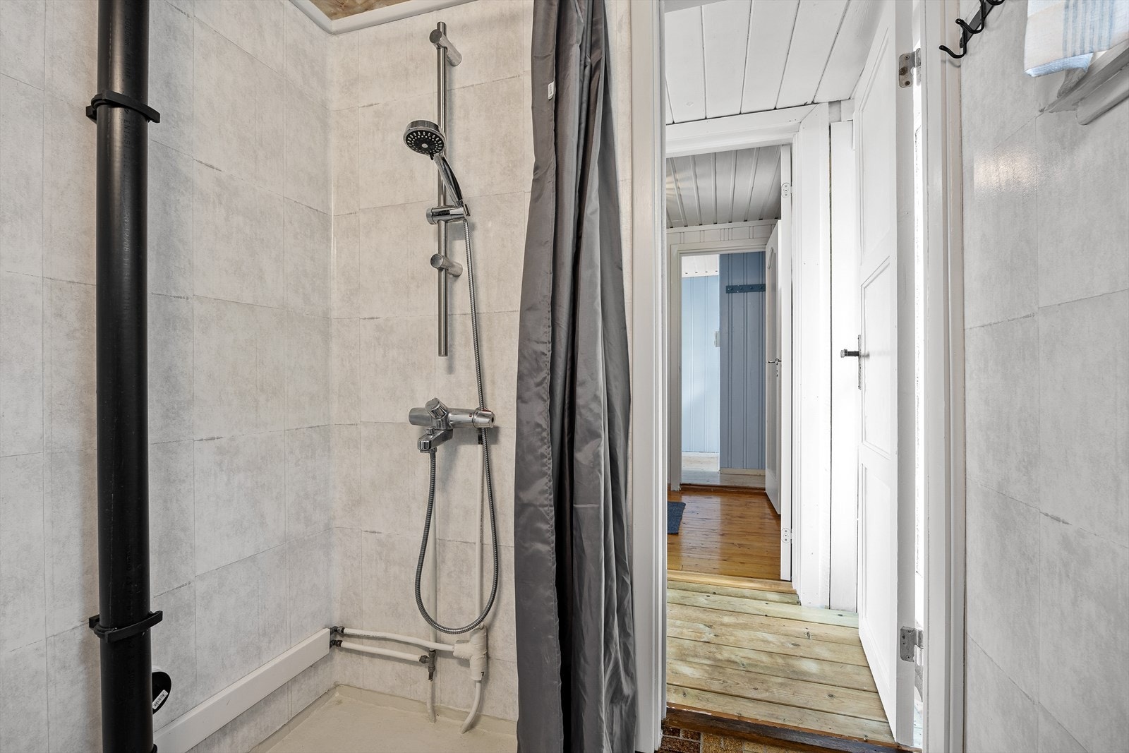 Tilbygget baderom med flislagt gulv og våtromsplater på vegg. Galleribilde