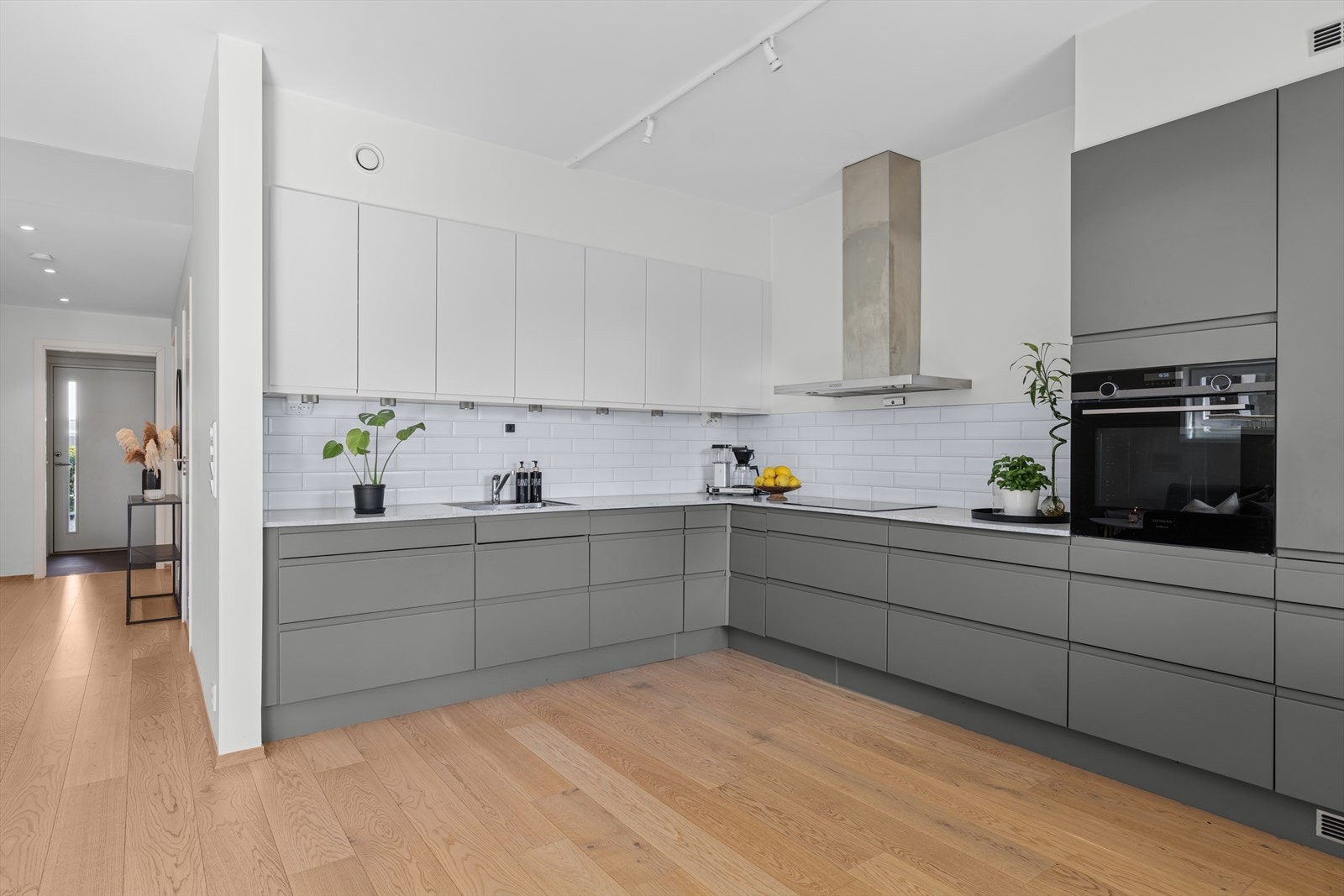 Stilrent og moderne HTH-kjøkken med slette fronter og benkeplate av typen laminat. Galleribilde