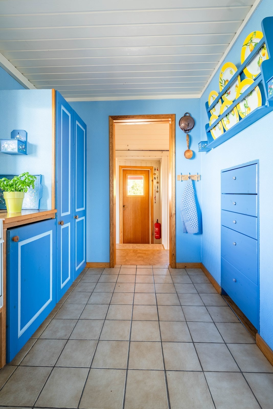 Under tallerkenhylla til høyre stod det tidligere et kjøleskap, men da det ble flyttet ut i gangen ble det en praktisk skufferekke. Galleribilde