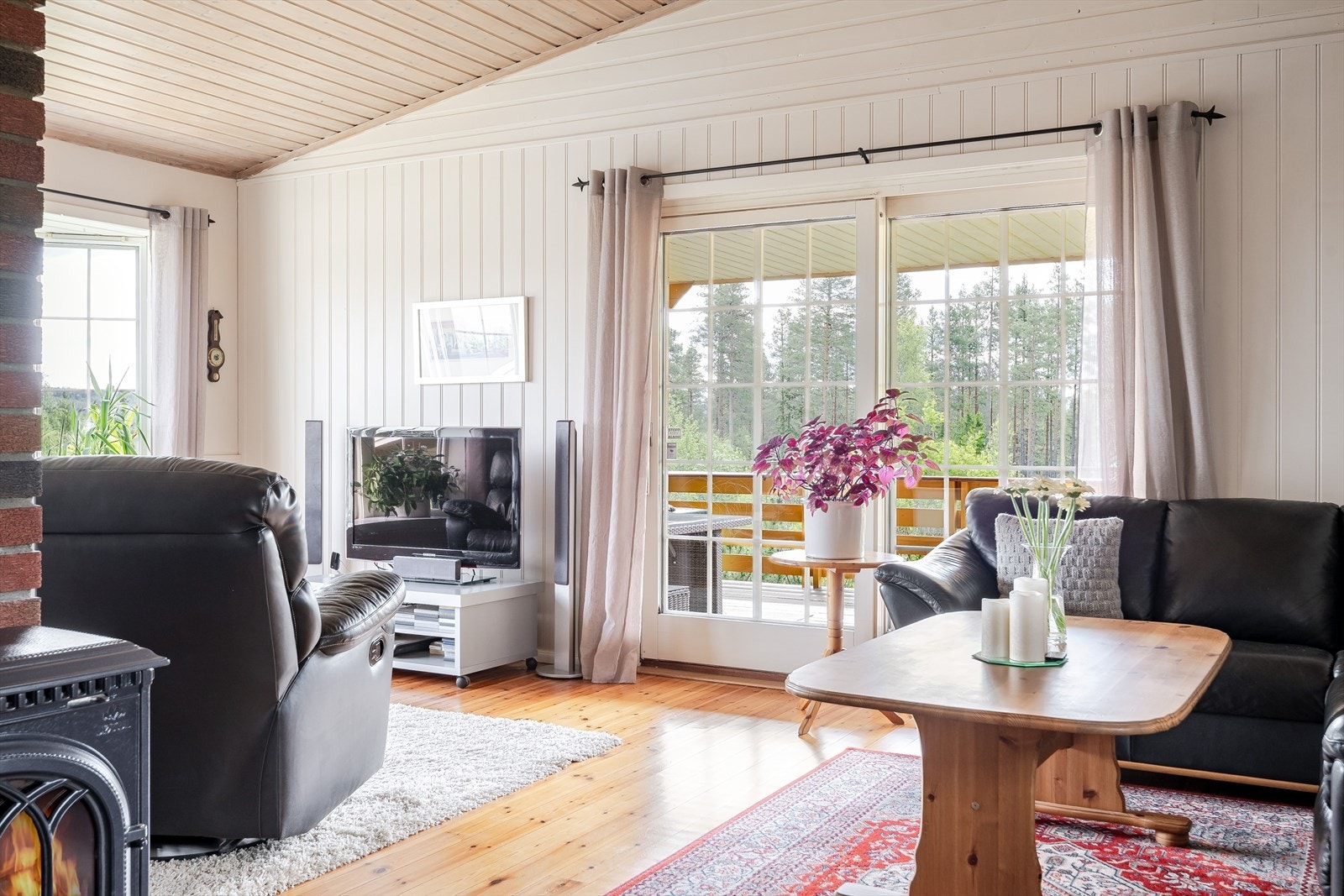 Stuen har store vinduer som slipper inn rikelig med naturlig lys og mønet himling som gir en luftig romfølelse. Galleribilde