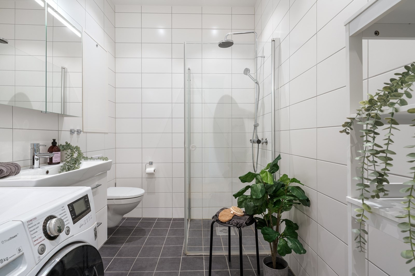 - Badet er lyst og fint, innredet med nedfelt servant, vegghengt toalett, dusjhjørne og opplegg for vaskemaskin - Galleribilde