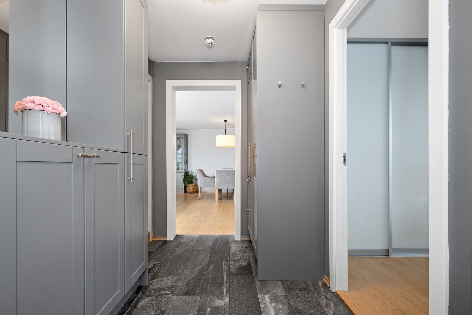 Entré med flislagt gulv og tilpasset garderobe med hylle og speil. Galleribilde