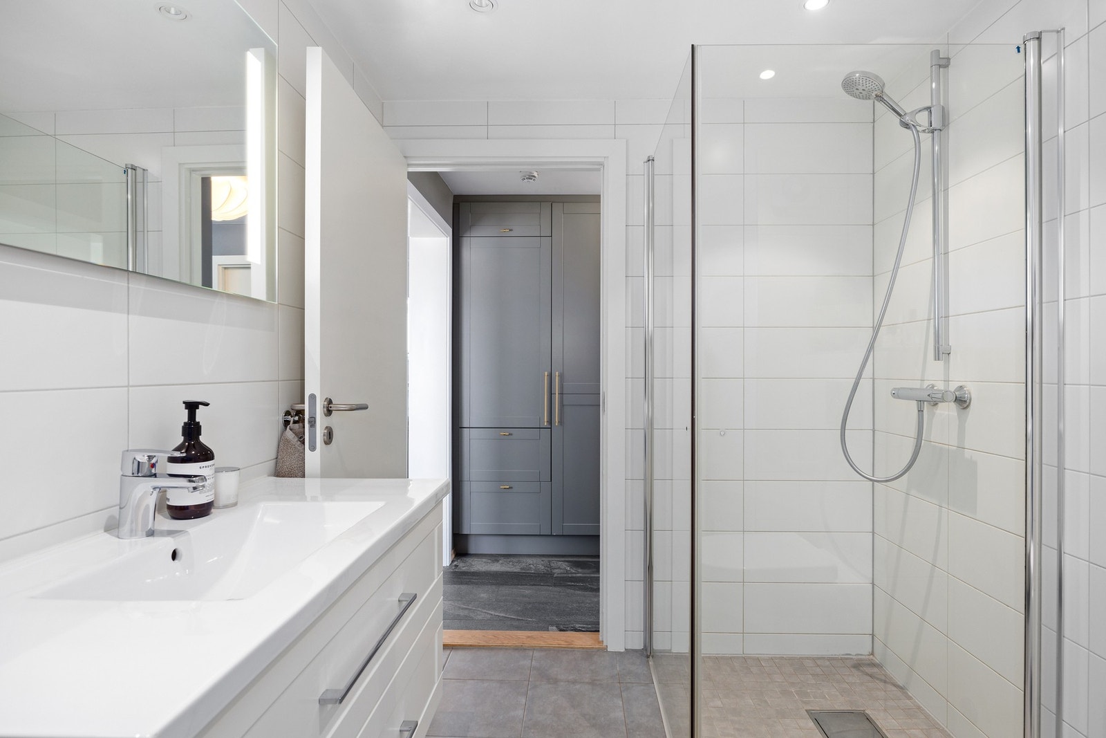 Et pent baderom med nøytrale fliser og inventar. Galleribilde