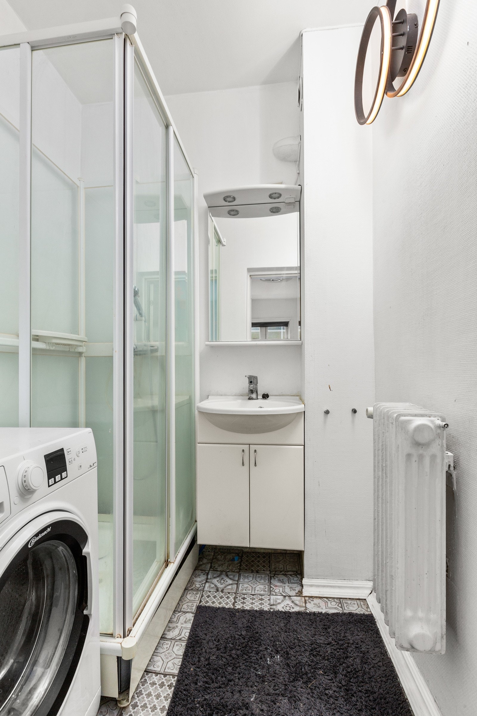 Badet er innredet med dusjkabinett, servantskap og opplegg for vaskemaskin. Galleribilde