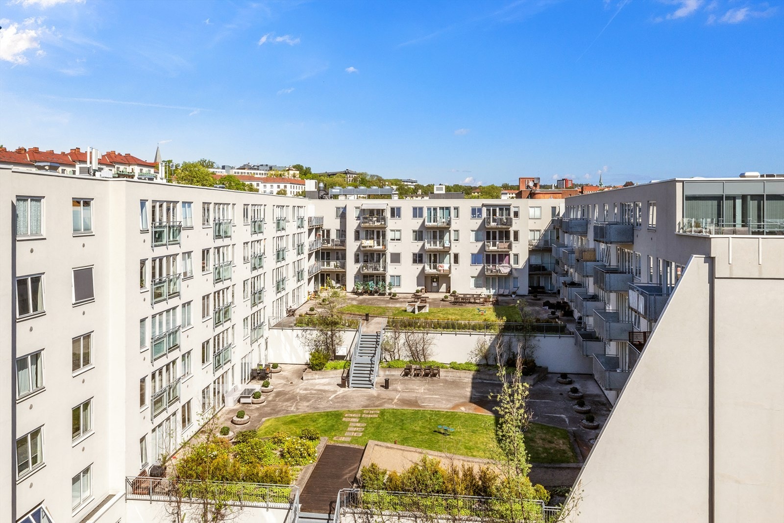 Indre atrium/bakgård er pent opparbeidet i 3 nivåer med blant annet gressplen, treplattinger med hagemøbler, blomsterbed og lekestativ for barn. Galleribilde