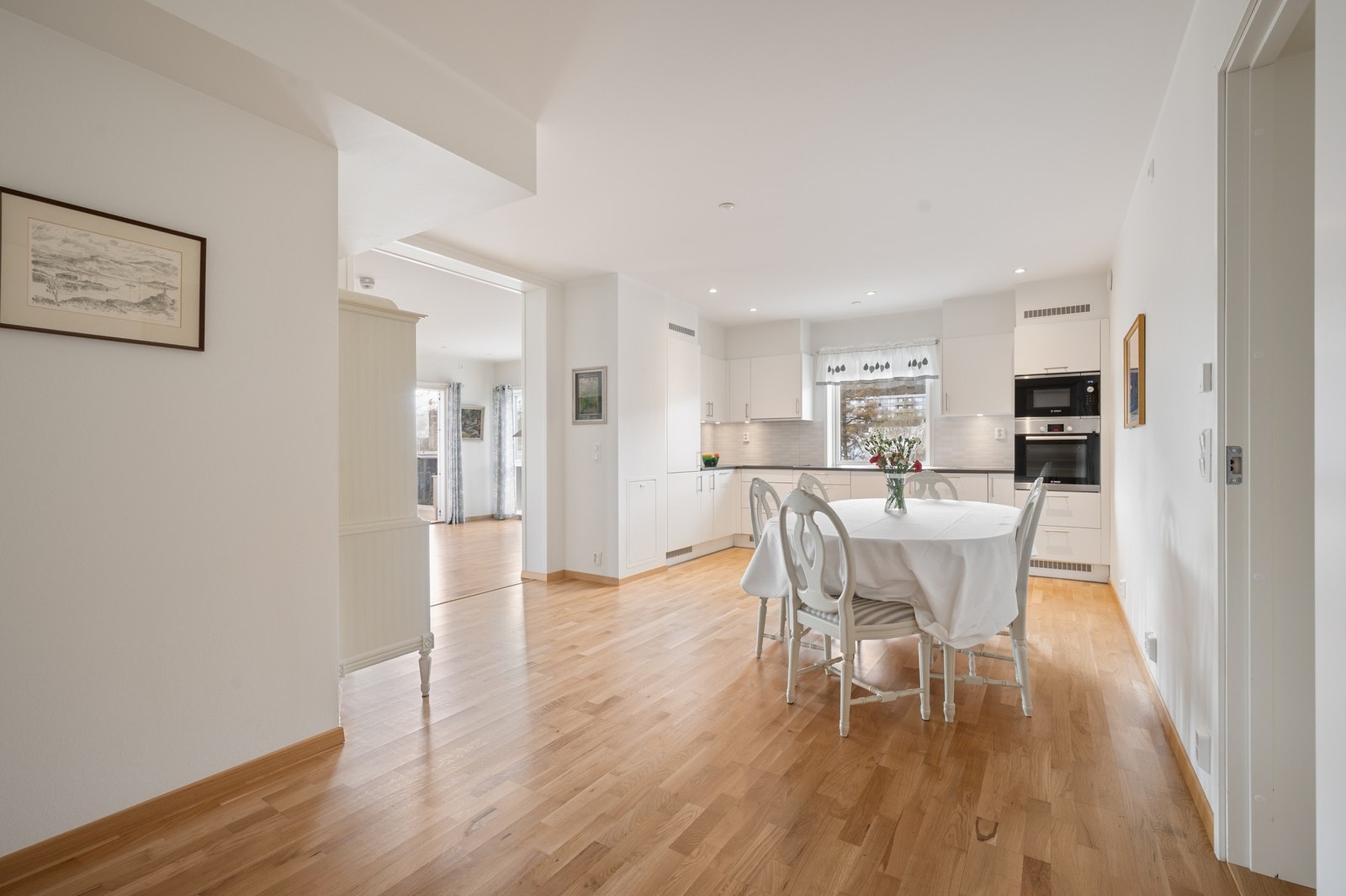 Tidløs og smakfull kjøkkeninnredning med hvite slette fronter Galleribilde