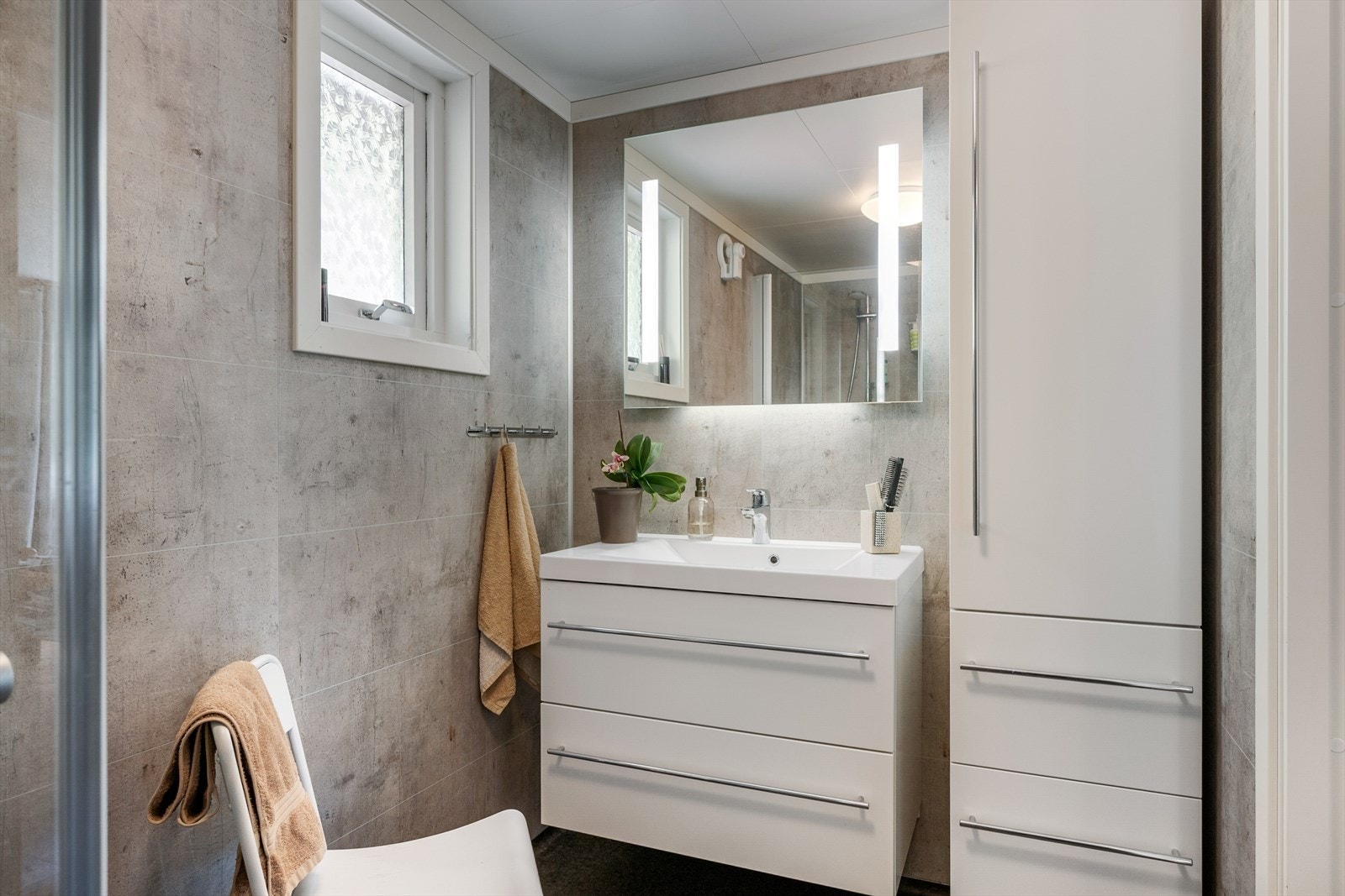 Badet ble oppgradert i 2020 med våtromsplater og gulvbelegg i grått. Galleribilde