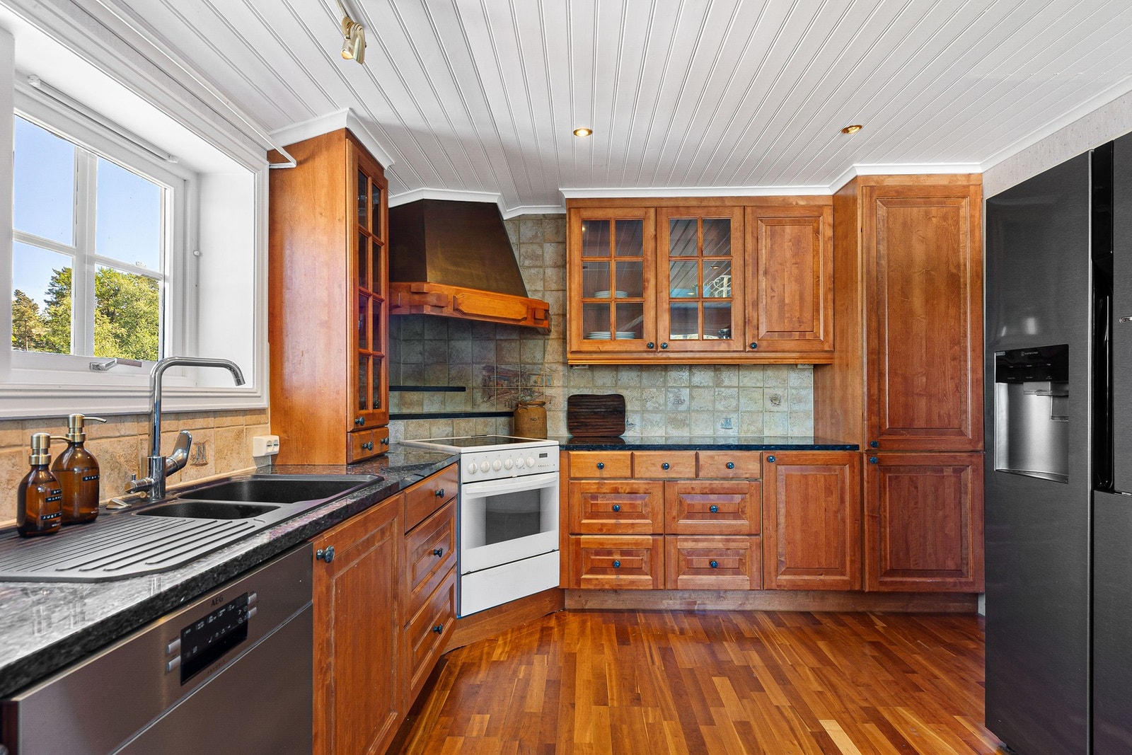 Romslig kjøkken med trefarget innredning. Godt med benkeplass. Galleribilde