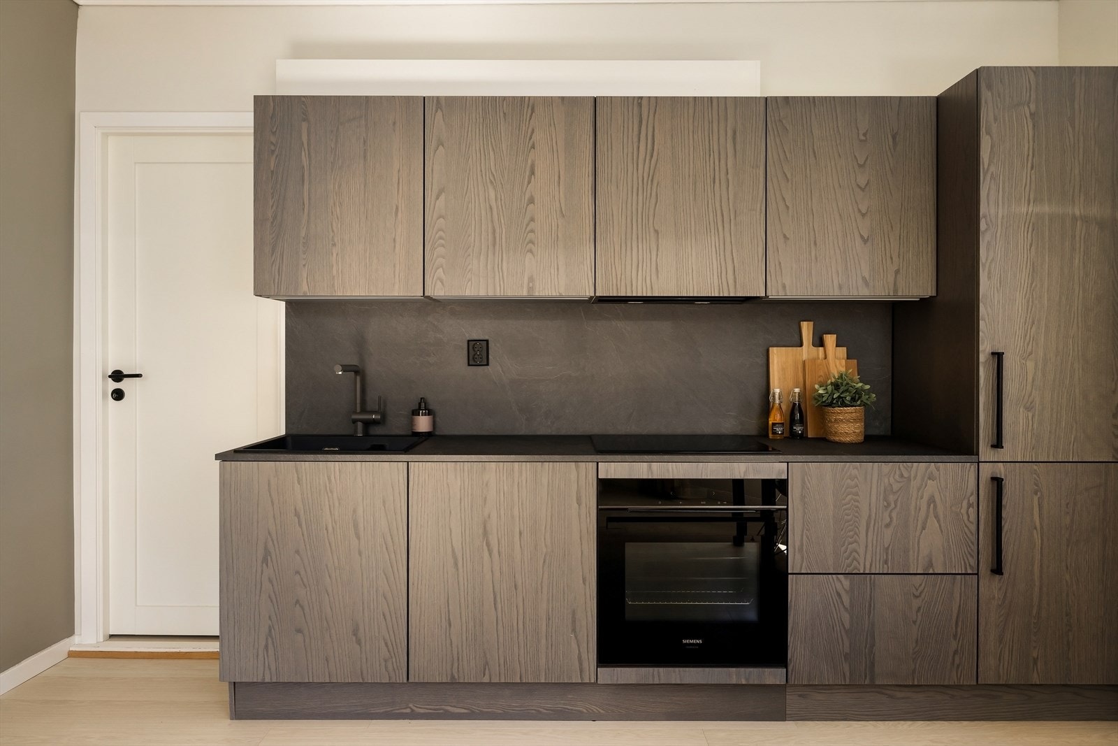 Kjøkkenet er lekkert utført i mørk eike utførelse med slette fronter. Galleribilde