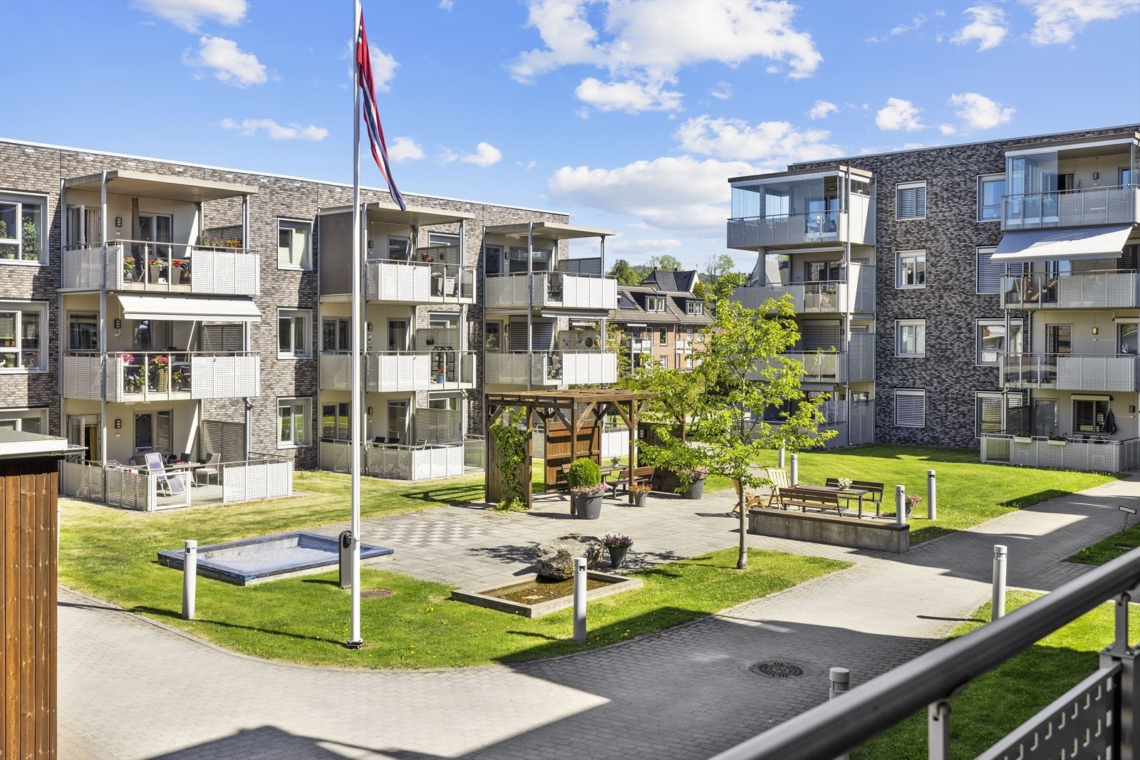 Schweigaards Plass borettslag er bygget som et atrium, med en lun og trivelig park med benker, pergola og vannspeil i senter - et populært borettslag med høy bokvalitet Galleribilde