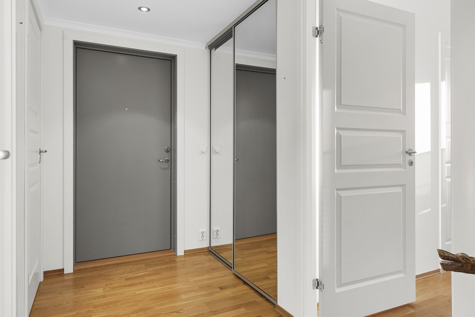 Fra entré/hall med skyvedørsgarderobe er det inngang til gjestetoalett, bad/vaskerom og ett soverom Galleribilde