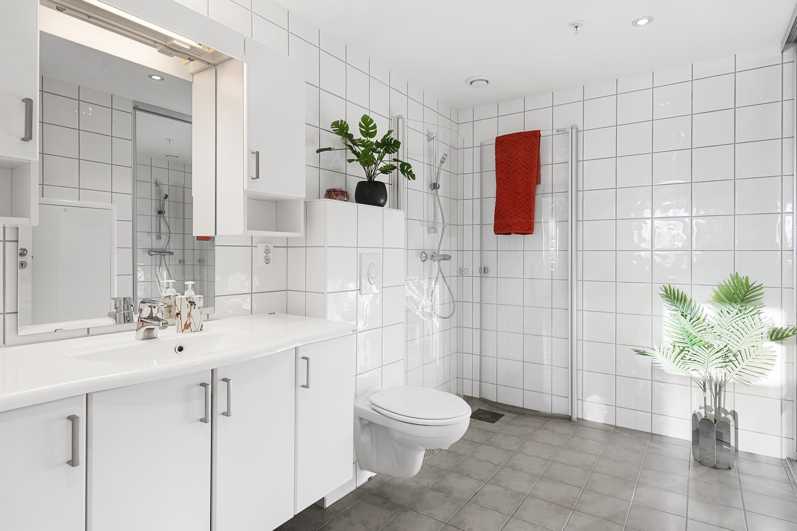 Baderommet har pene fliser på vegger og gulv, med varmekabler Galleribilde