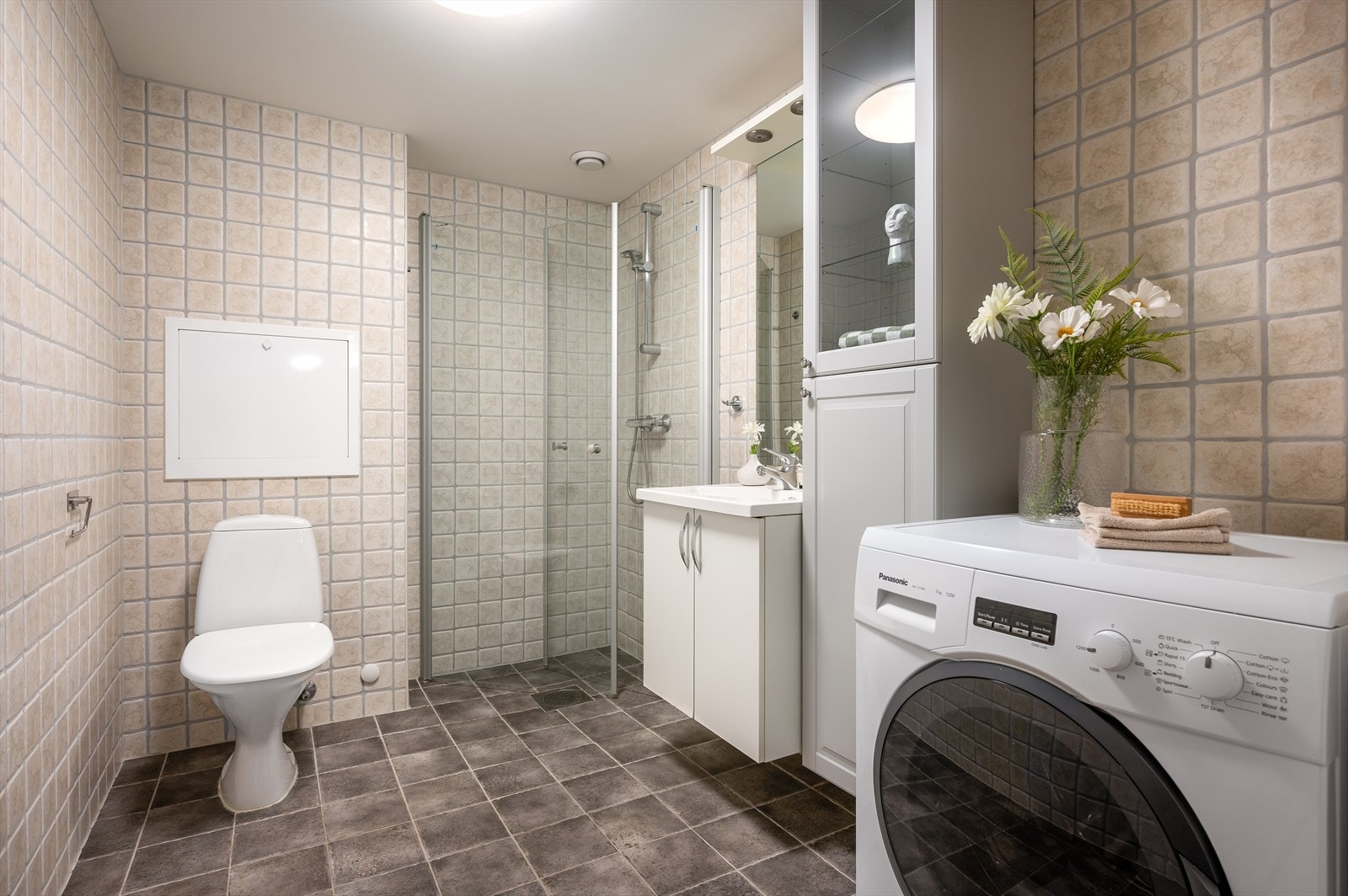 Badet er utstyrt med servant og underskap, ekstra skap, opplegg for vaskemaskin og dusjhjørne med innfellbare glassdører. (Vaskemaskin medfølger). Galleribilde