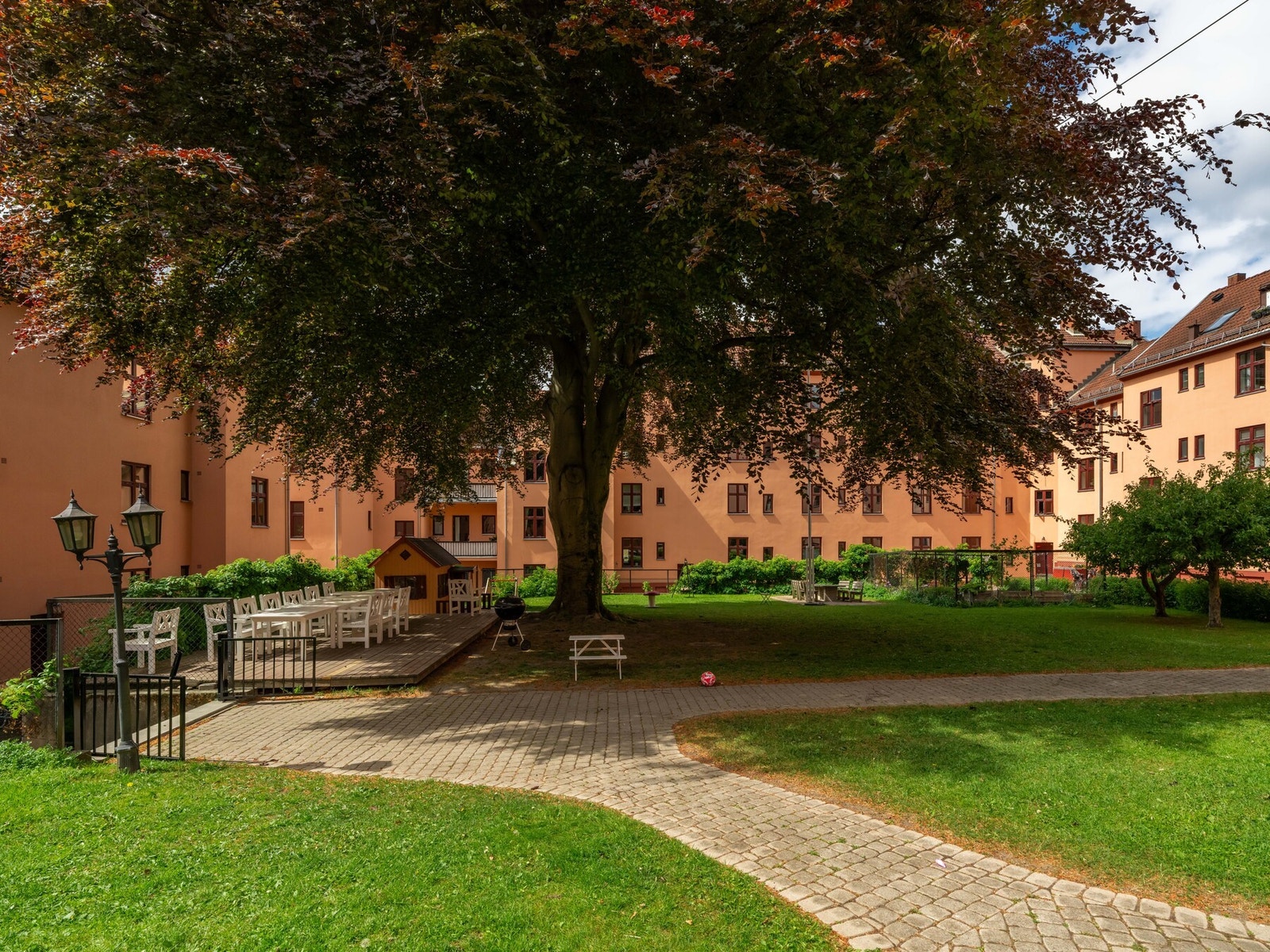 Bakgården er lukket fra gaten, og har store grøntarealer, eple- og plommetrær, samt grill og sittegrupper. Dette skaper en skikkelig godfølelse: Rett og slett en egen oase midt i byen! Galleribilde