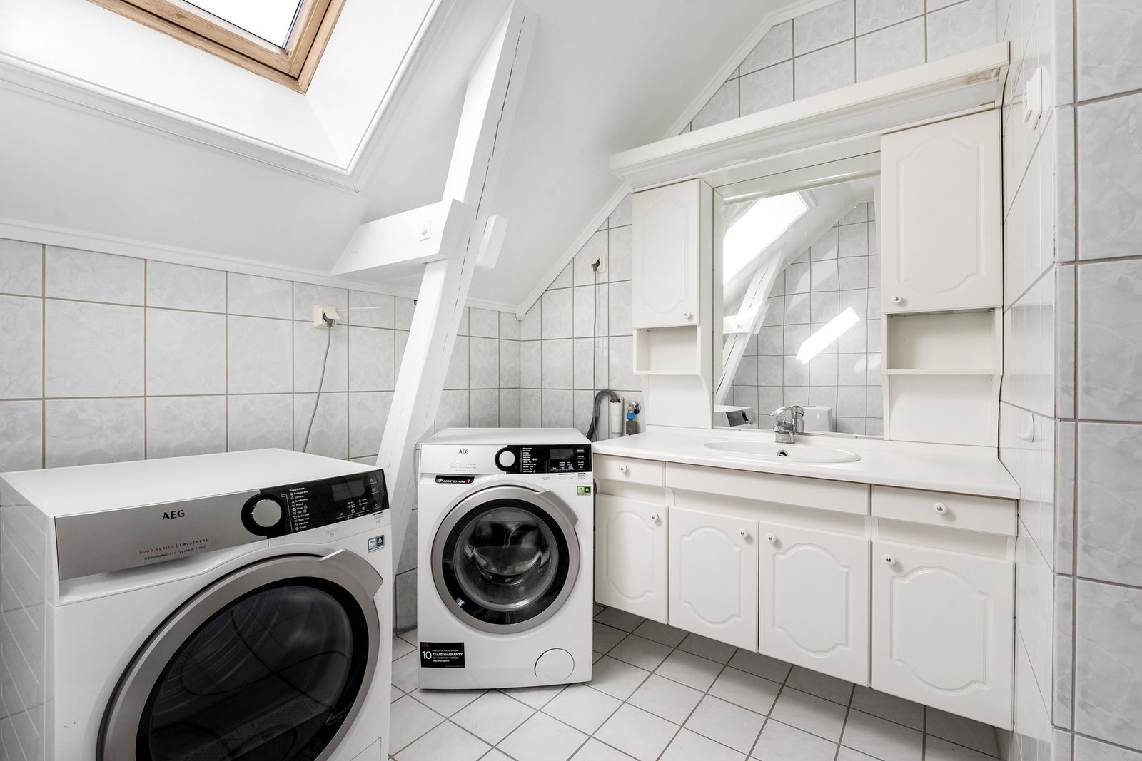 Flislagt bad fra omgjøringen ca. 1997. Varmekabler i gulv, WC, dusjhjørne, innredning med servant og speil, opplegg til vaskemaskin. Galleribilde