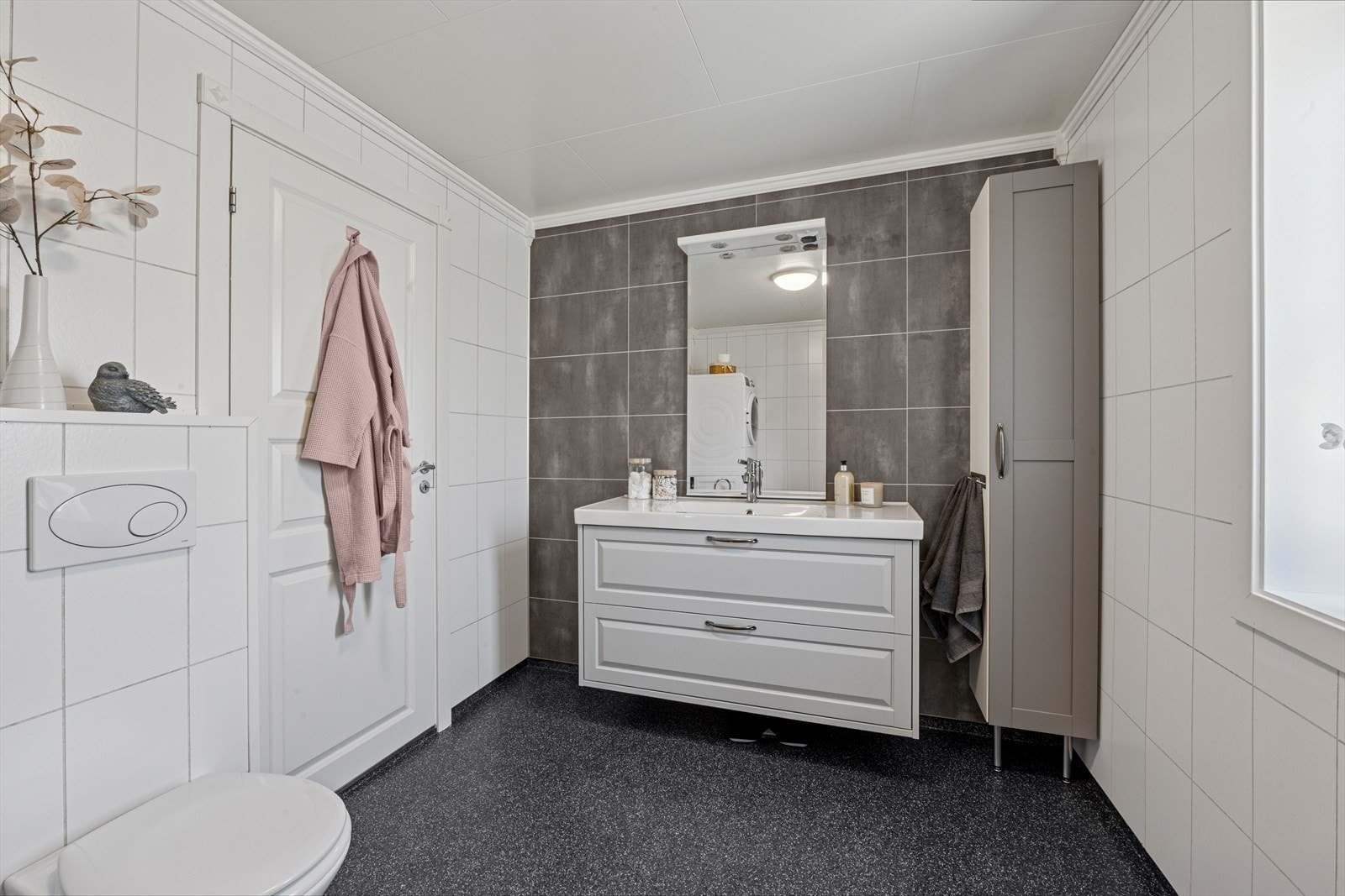 Boligen har et romslig bad i lyse farger Galleribilde