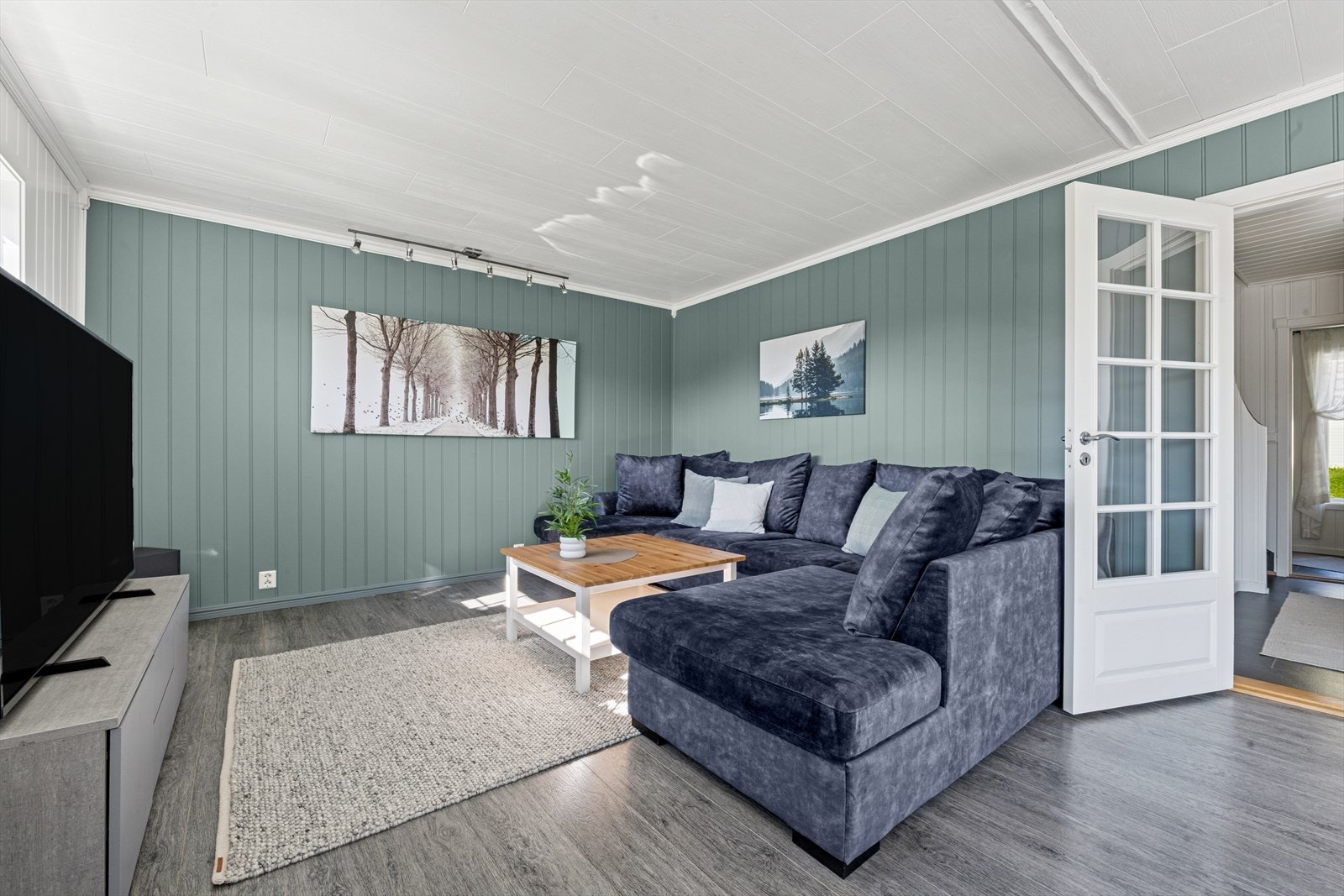 Her kommer man inn til en innbydende stue med moderne farger Galleribilde