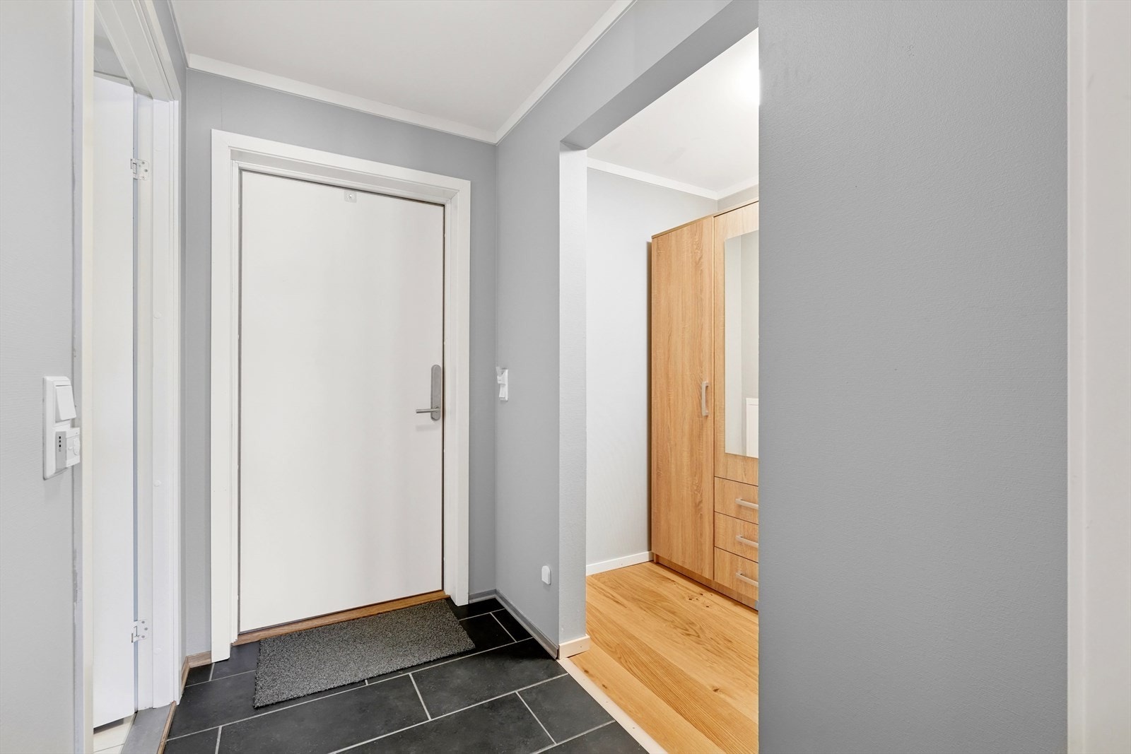 Entréen har praktiske fliser på gulvet, og det er en garderobe like innenfor inngangsdøren. Galleribilde