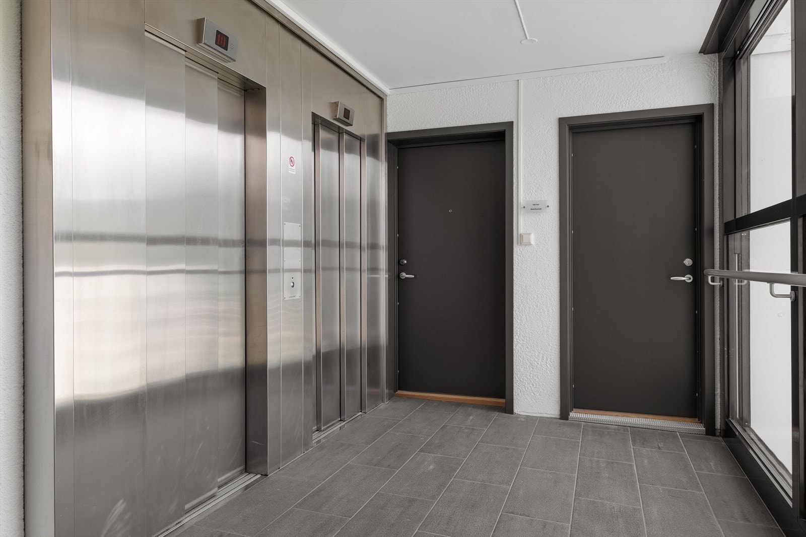 Inngangsparti i ellevte etasje. Ny dør til leilighet og vaskerom samt fliser på gulv ble oppgradert i 2025. Galleribilde