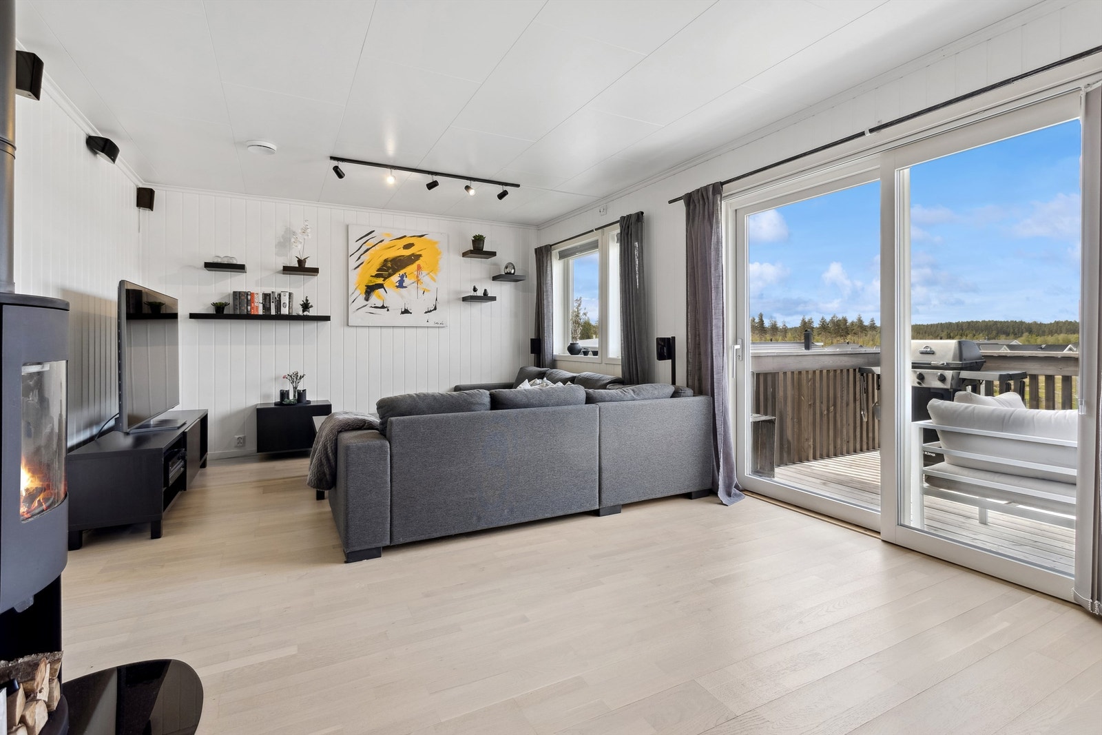 Stue med store glassflater mot vest - Innvendig solskjerming med persienner og lamellgardiner. Bred skyvedør til balkongen Galleribilde