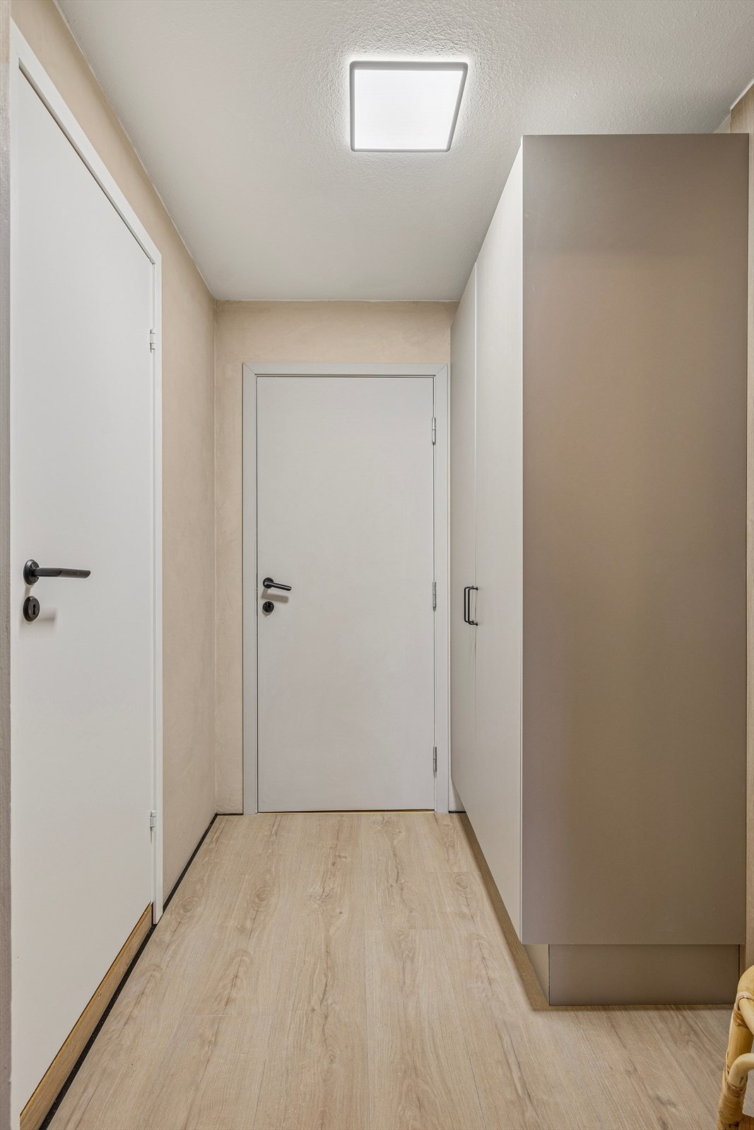 En stilren og praktisk garderobeløsning sørger for effektiv oppbevaring. Det er lagt pent Alloc laminatgulv (Rodeo drive) i både entré og stue/kjøkken. Galleribilde