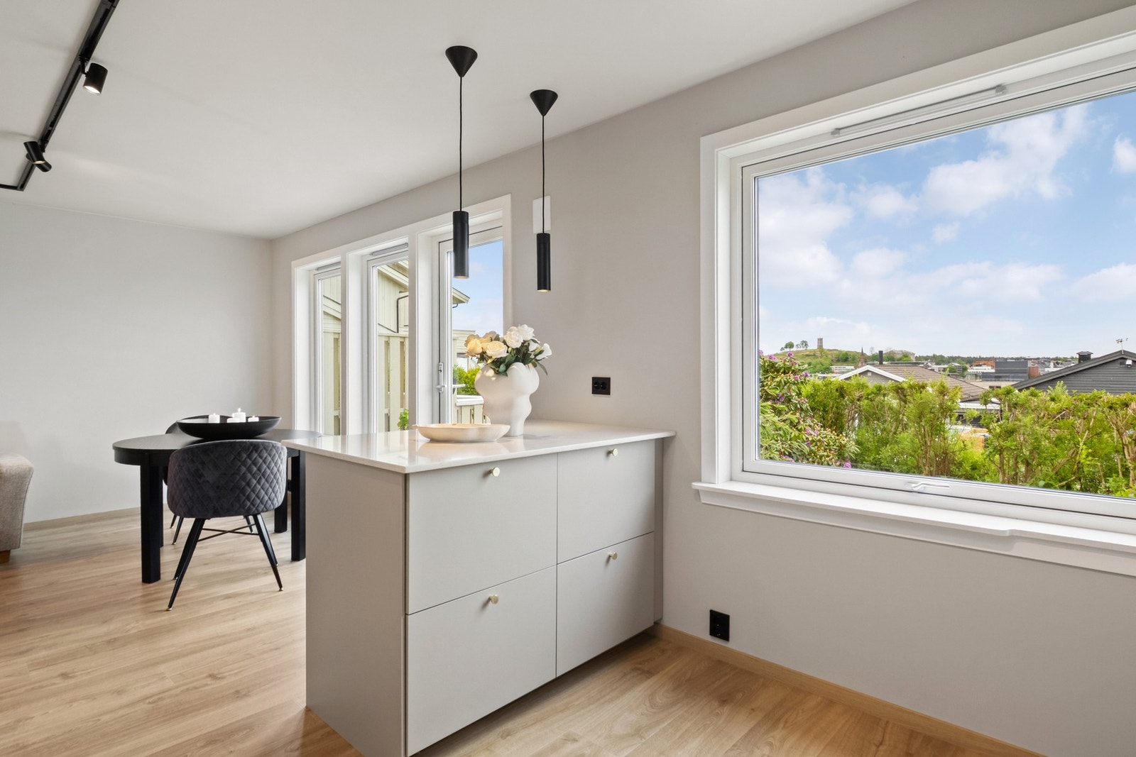 Kjøkkenet har et stort vindu, samt benkebelysning, spotskinne i taket og pendellemper over barløsningen, noe som bidrar til en ekstra lys og trivelig arbeidssone. Galleribilde