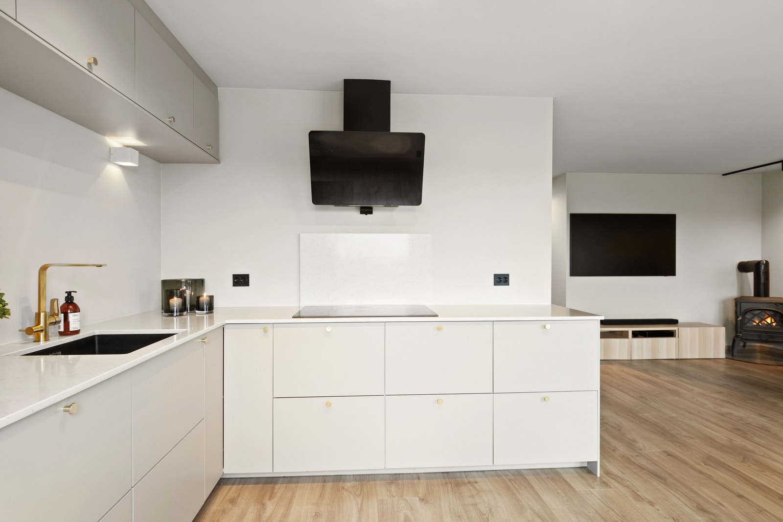 Innredningen har takoppforede skap, grå, glatte fronter med messingknotter og benkeplate i tynn, lys Silestone. Galleribilde