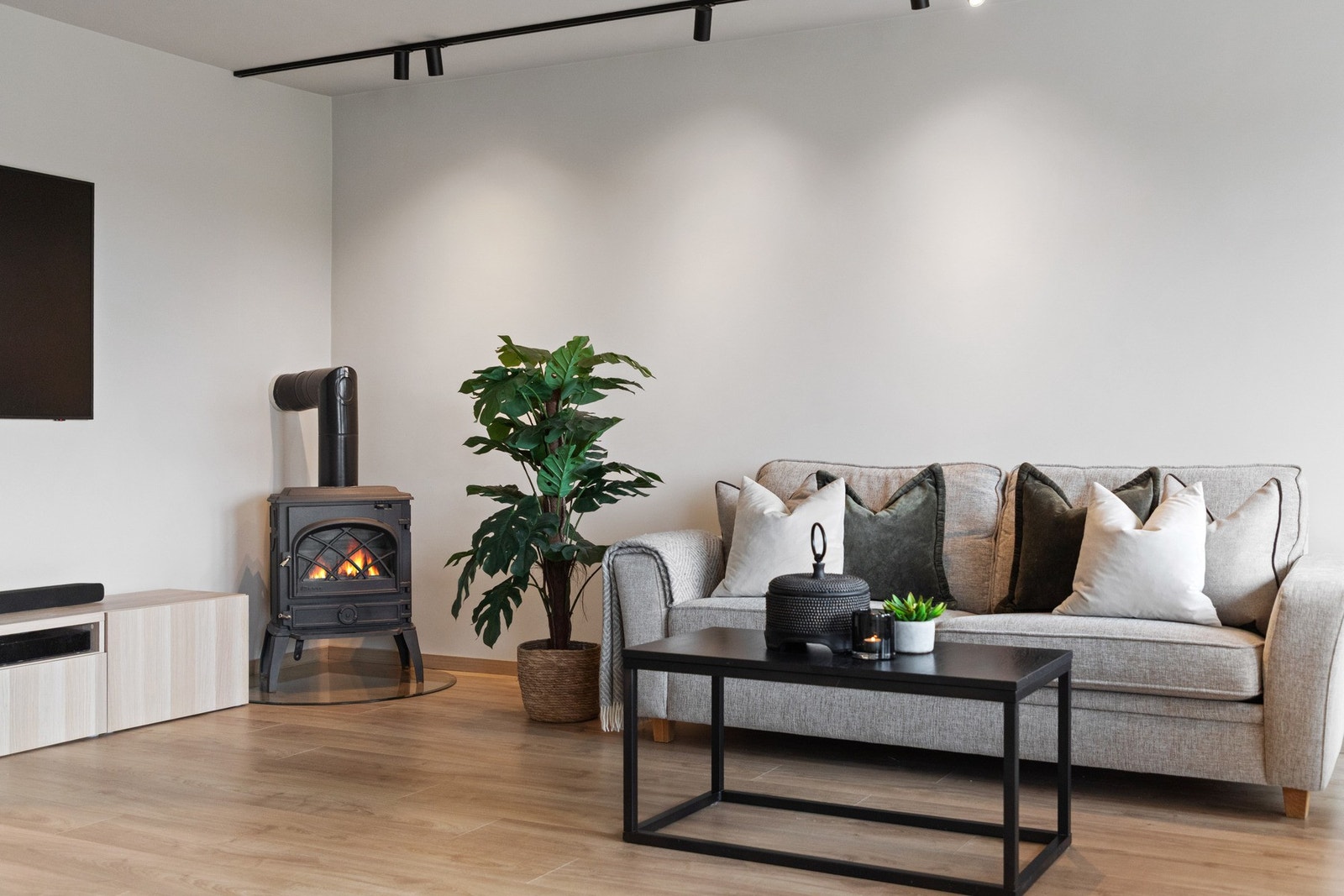 Stuen lar seg enkelt møblere med både spisebord og tv-lounge, og en peisovn i hjørnet skaper lun hygge. Galleribilde