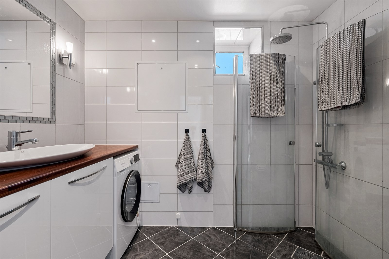 Baderommet er flislagt med termostatstyrte varmekabler i gulvet og downlights i taket Galleribilde