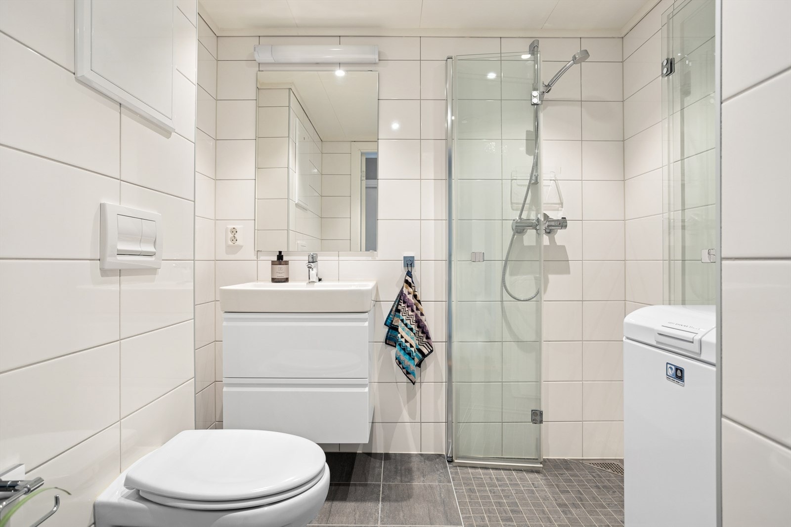 Pent baderom på 3,3 kvm renovert i 2018 (dokumentasjon foreligger). Det er keramiske fliser på gulv, vegger og takplater med led spotlights i himling.
Det er varmekabler i gulv og avtrekksventil i himling. Galleribilde