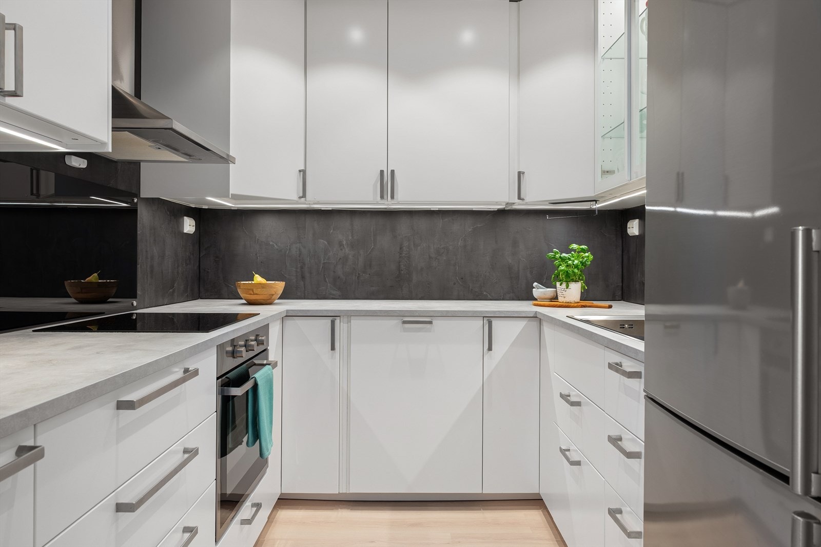 Stilrent fra 2023 med hvite, glatte fronter og laminert benkeplate. Galleribilde