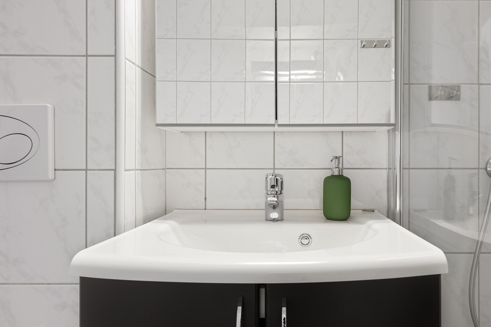 Det er innredet med foldedører i dusj, veggmontert toalett og servant med underskap og speil med belysning. Galleribilde