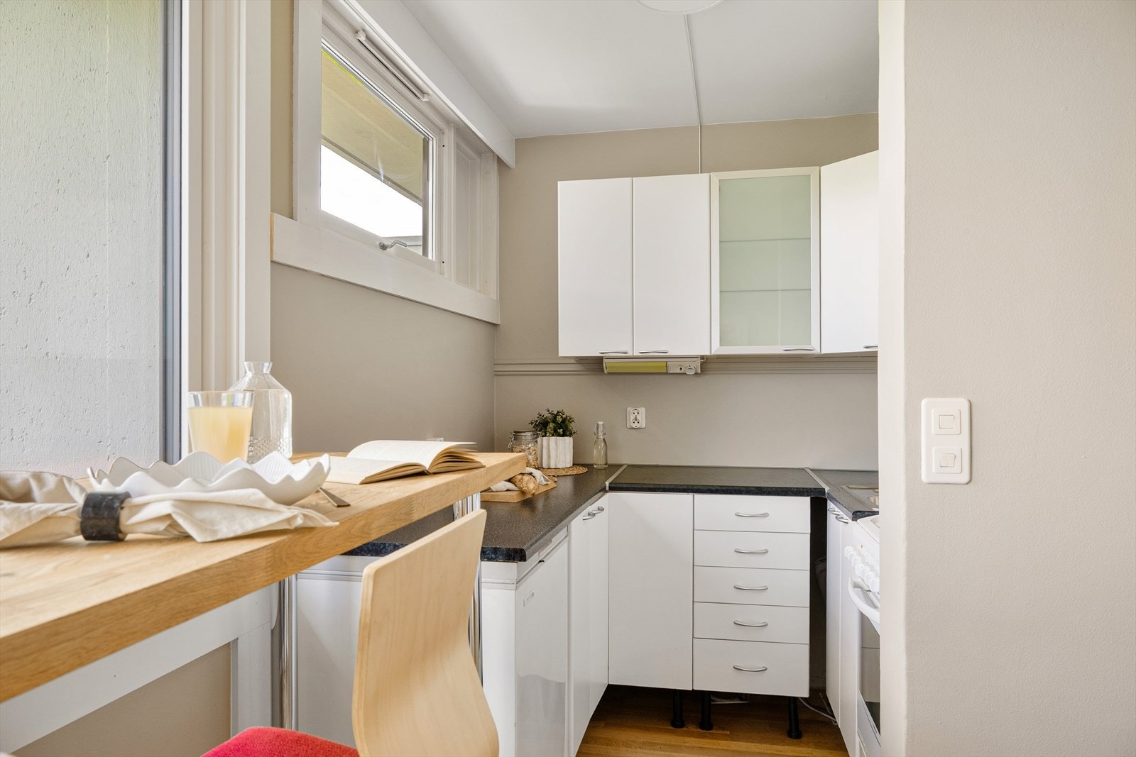 Kjøkkeninnredningen har hvite fronter og benkeplate av laminat. Galleribilde